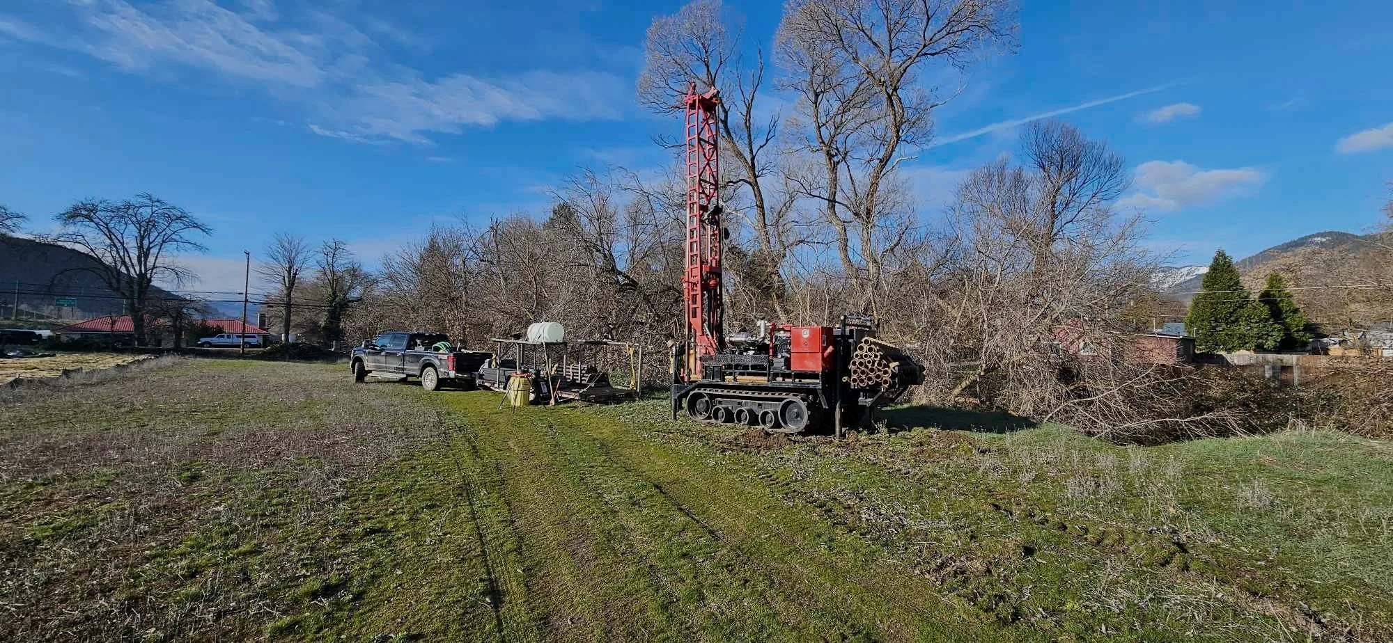 Landscape with drilling rig and truck on grassy field