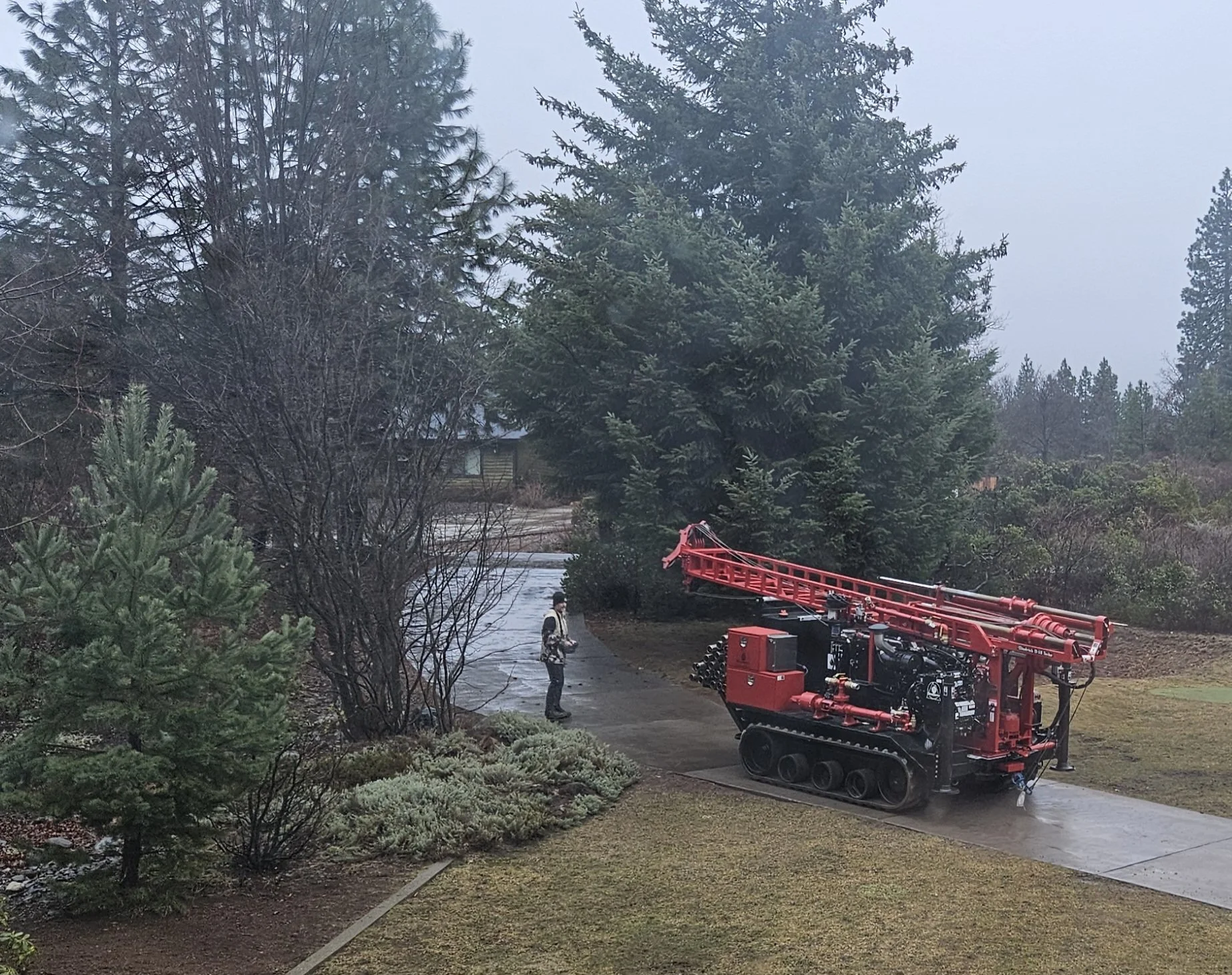 Red tracked machine with industrial equipment in a forested setting
