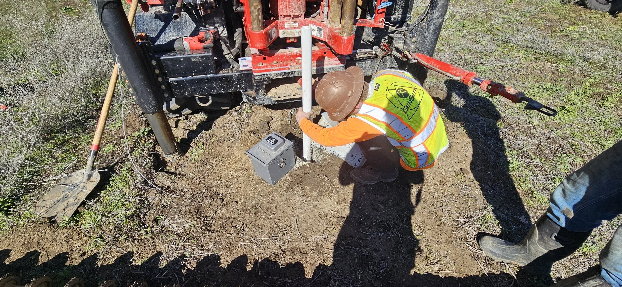 Person conducting soil testing with drill rig in construction site