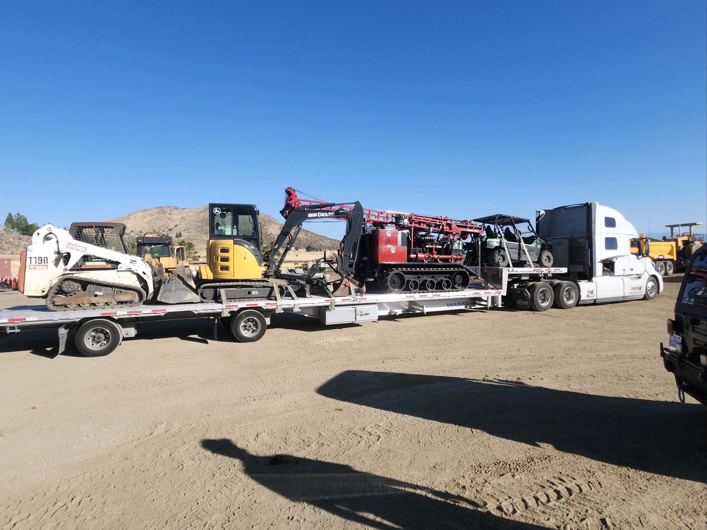 Flatbed truck transporting construction equipment