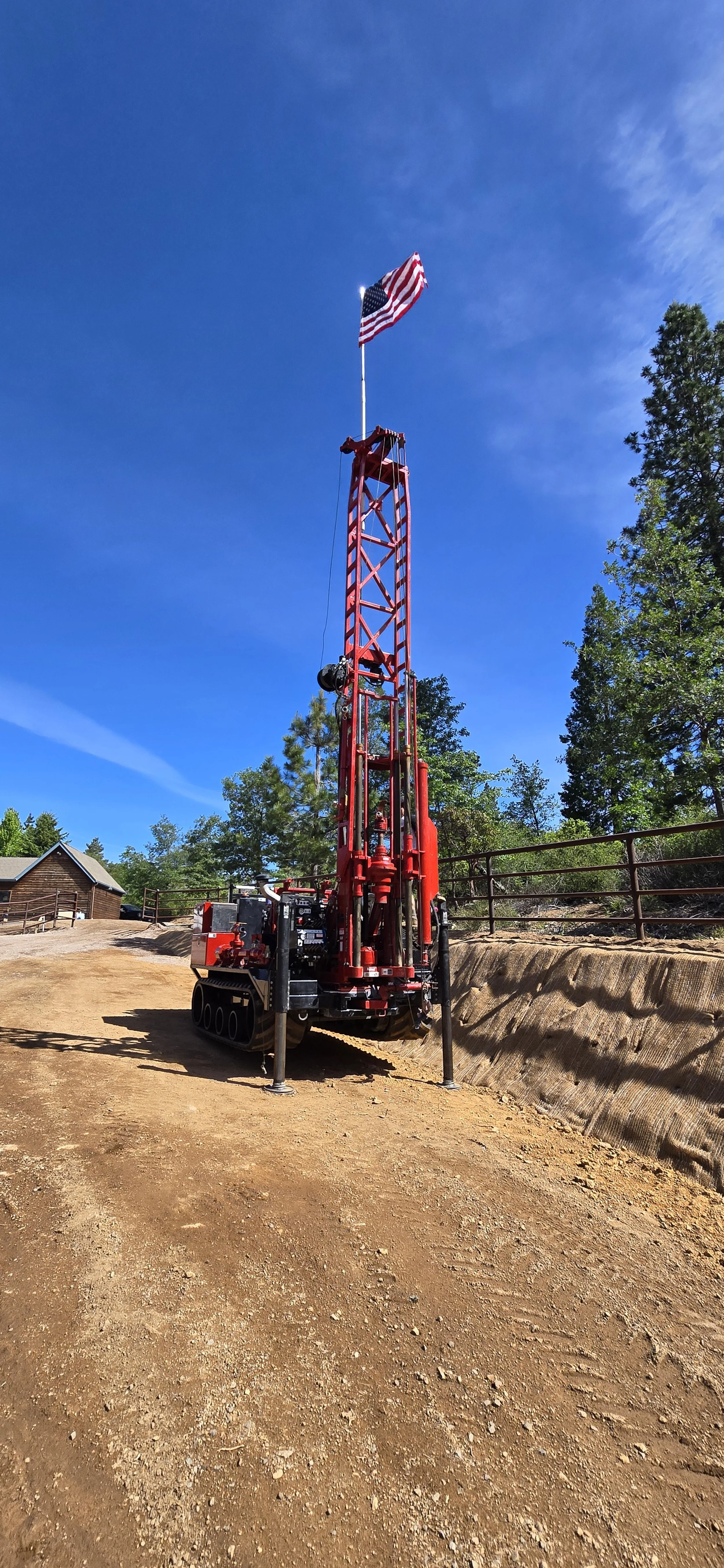 Red drilling rig with American flag in a rural setting