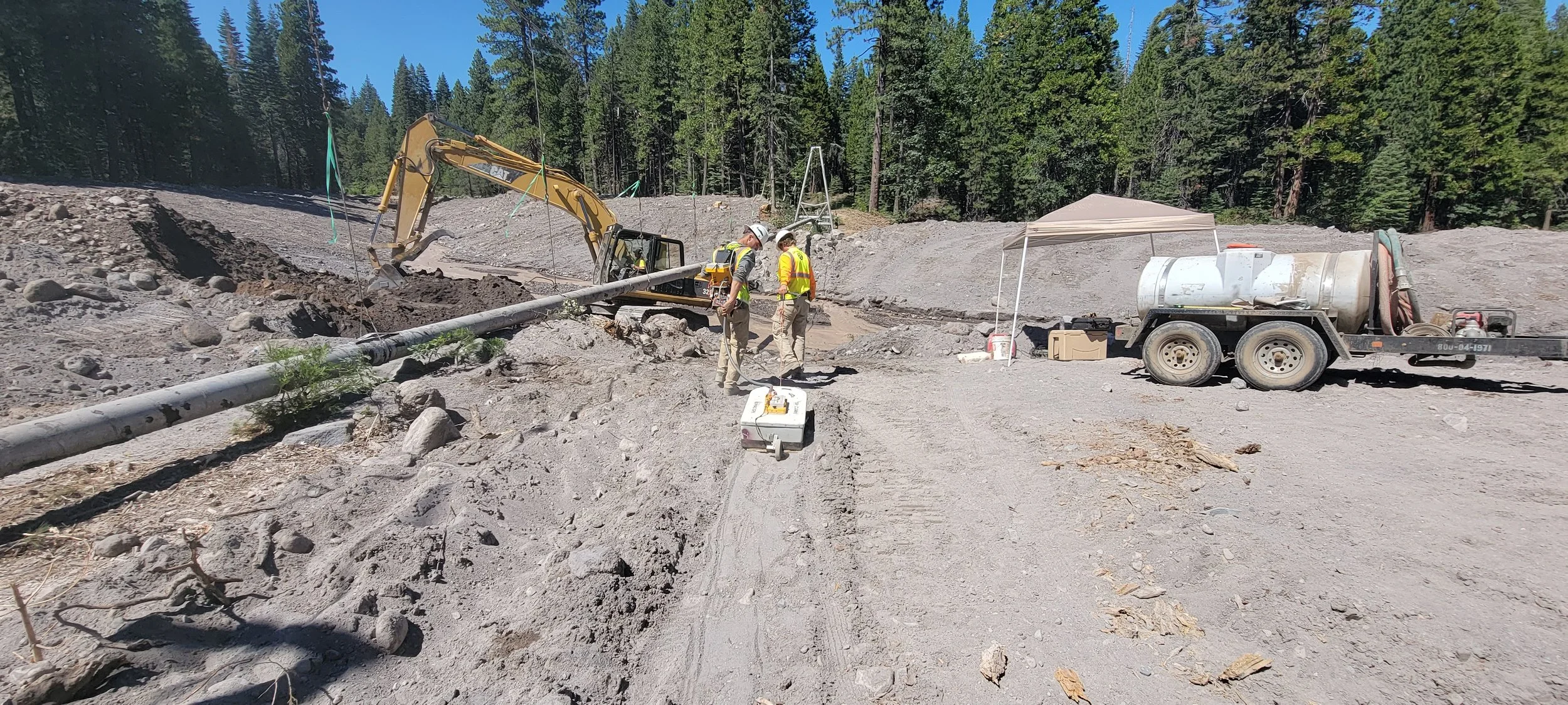 Construction site with excavator, workers, and trailer