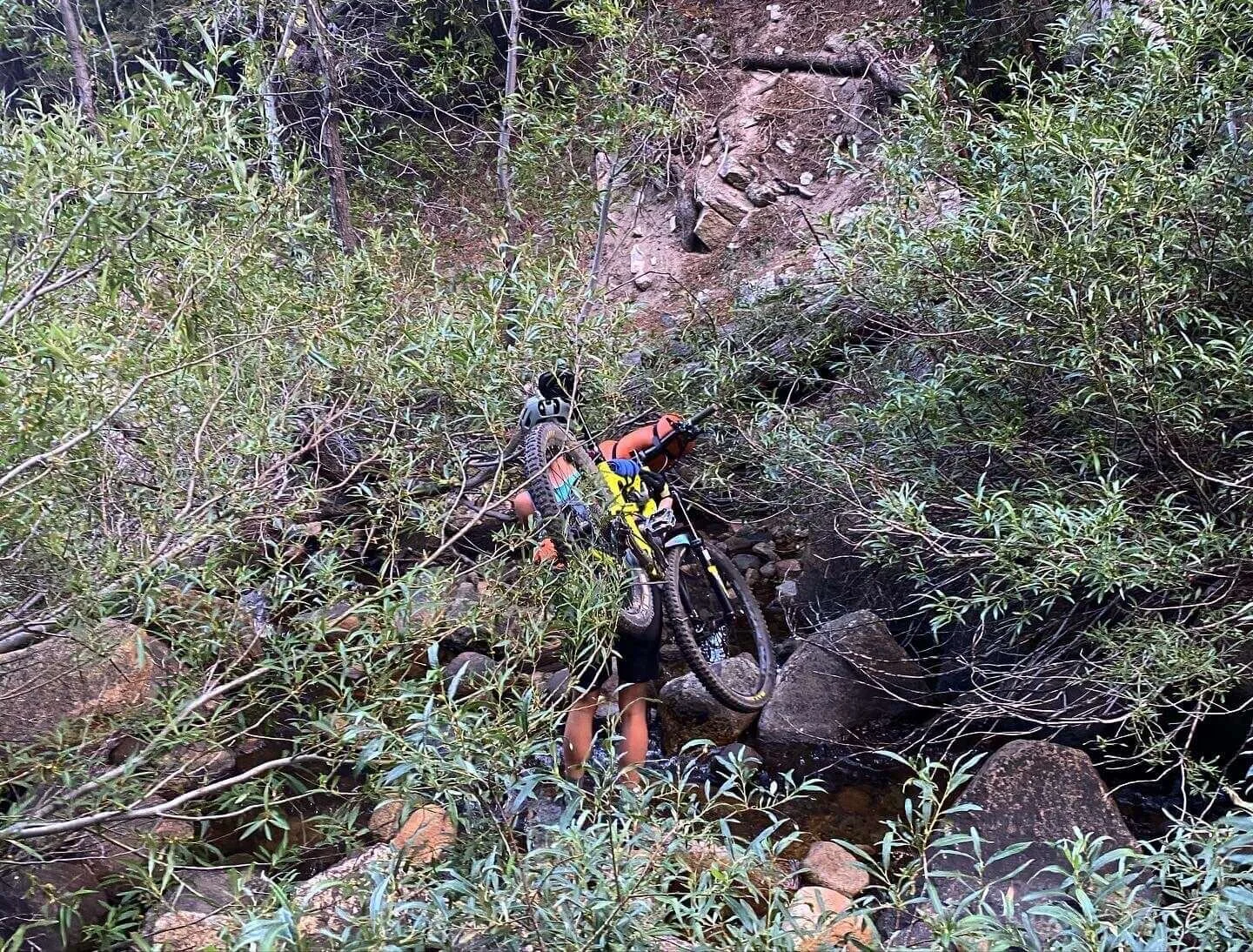 person holding bike over shoulder