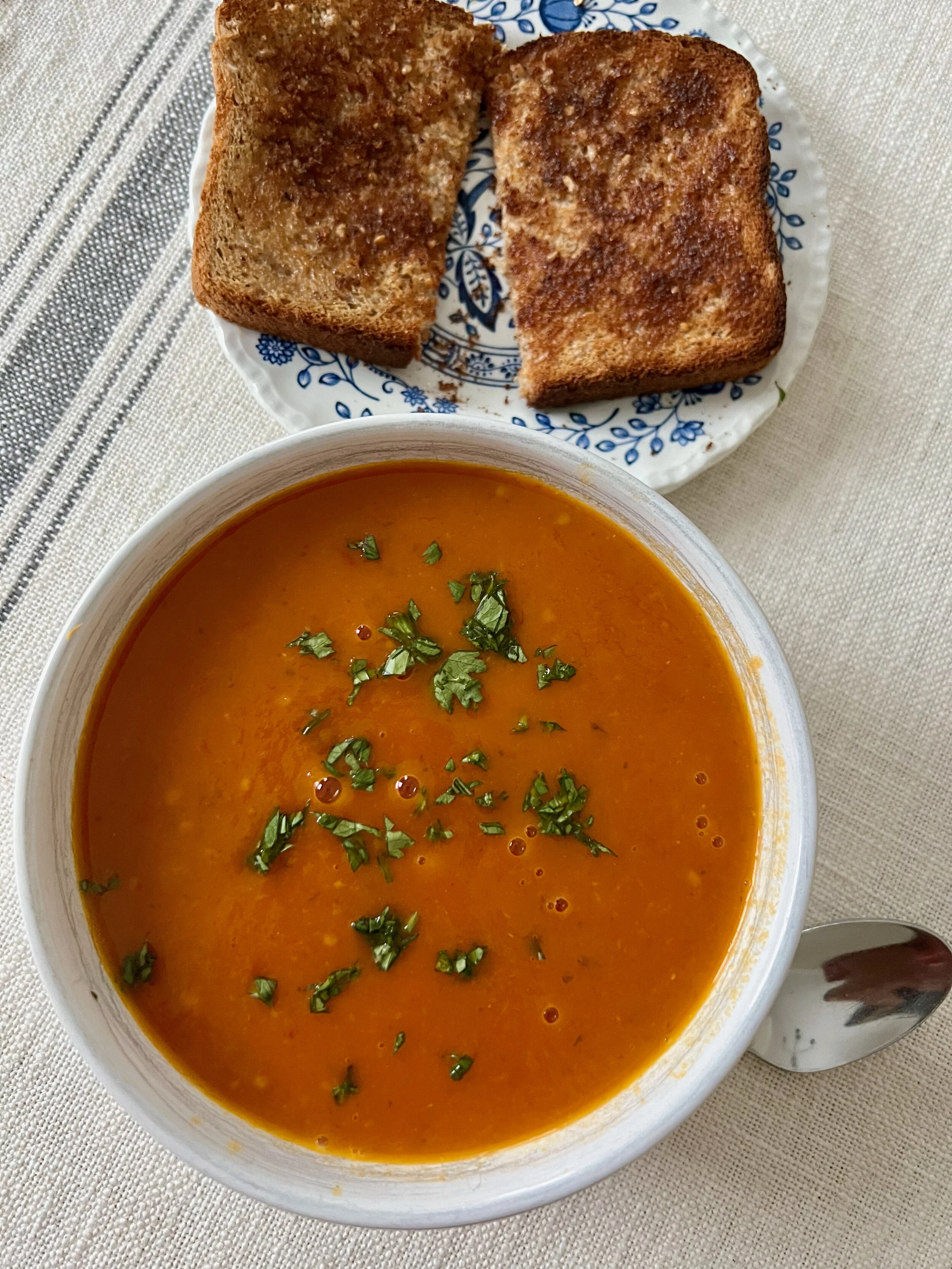 Bowl of Coconut Tomato Soup with a Sandwich
