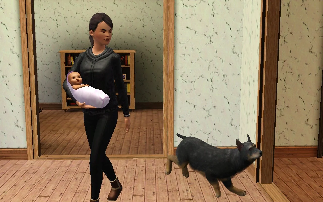 Dorothy walks into the front room of Button Ranch from the archway of Matthew’s office, holding baby Mara with a grumpy expression, her face turned slightly towards senior dog Petunia running or jumping around.