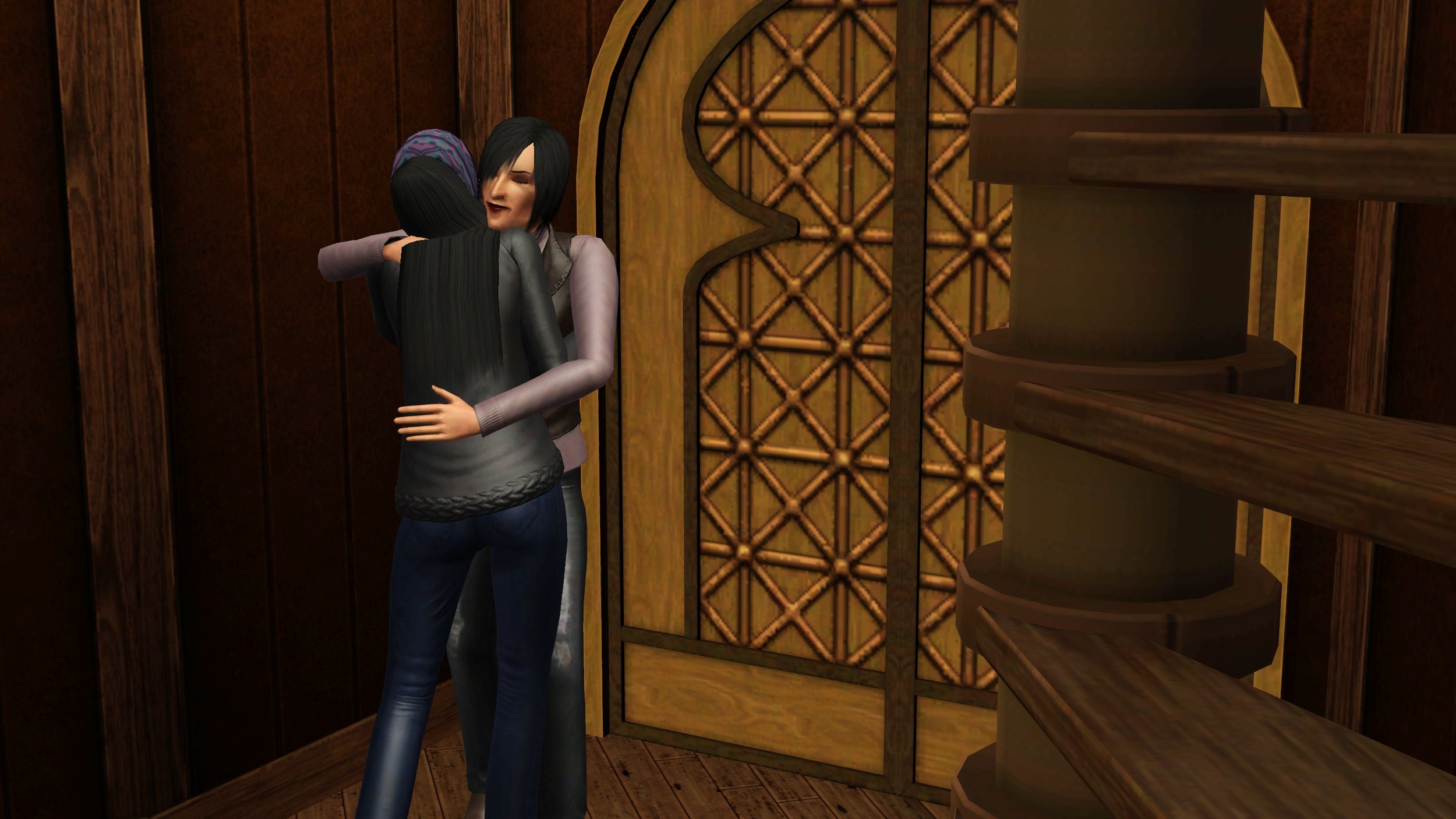 Colette hugs Emery tightly with closed eyes; Emery hugs her in return but only her back is visible. They are standing in Emery’s home’s entrance, with part of a spiral staircase and an ornate double door in the frame.