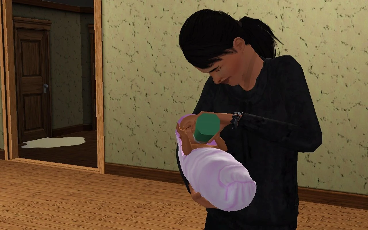 Dorothy looks exhausted and/or deeply sad, head lowered, as she holds baby Mara with one arm and bottle feeds her with the other. In the background, a water puddle has formed under a door. She is wearing a black hoodie.