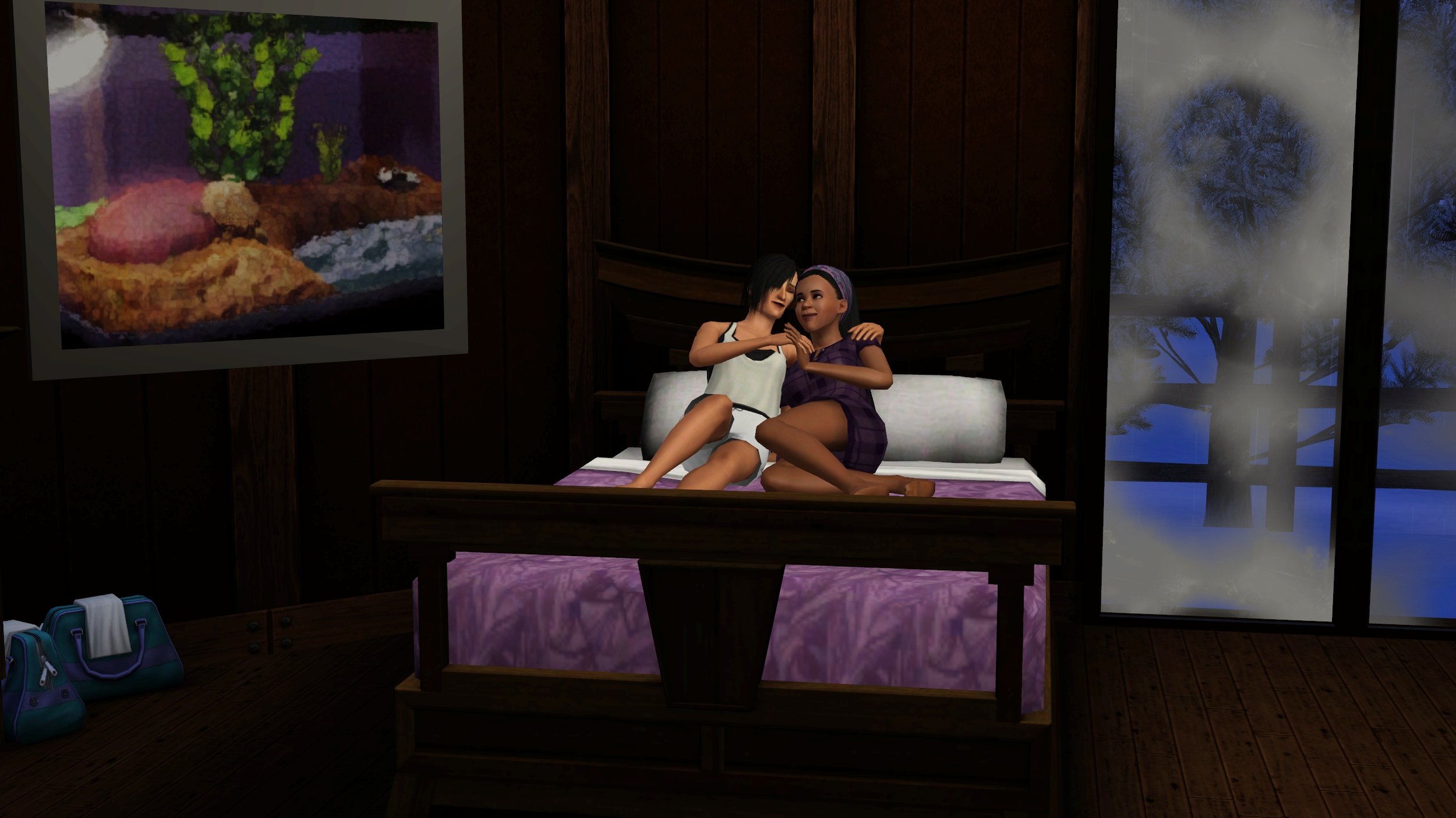 Sims Colette and Emery cuddle in a bed in pajamas. On the right, frost on two large windows obscures the snowy winter night outside. On the left, Colette’s two duffel bags below a large painting of Emery’s pet turtle.
