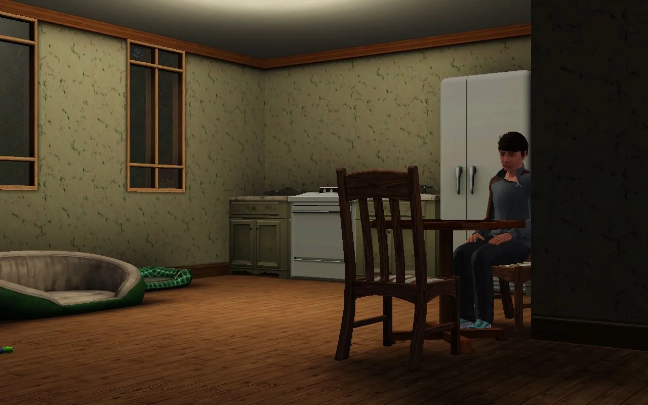 Matthew sitting alone, absently staring at the small dining table in front of him. The image’s framing makes the kitchen look large and empty next to him.
