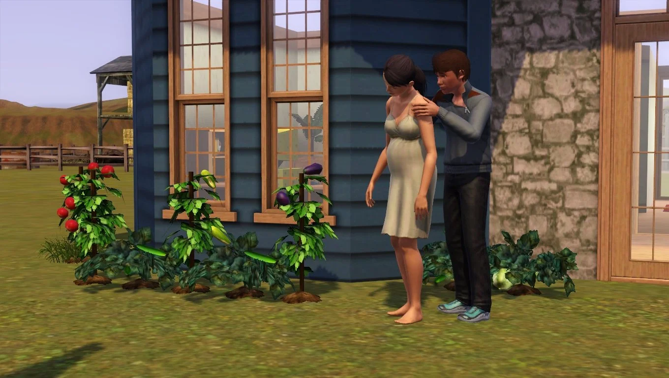 Matthew massages pregnant Dorothy’s shoulders in front of a row of thriving garden plants near the front door of their home on a sunny day.