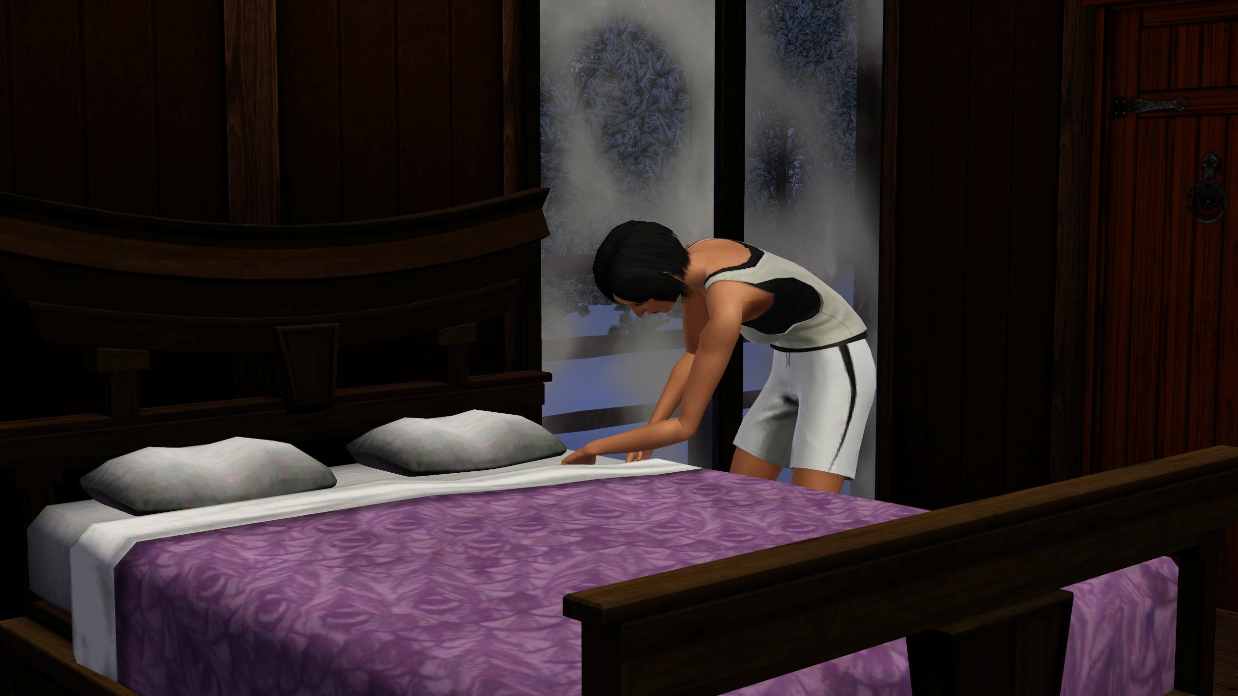 Colette straightens the blankets as she finishes making the bed. She wears a tank top and shorts, standing in front of two large frosted windows.