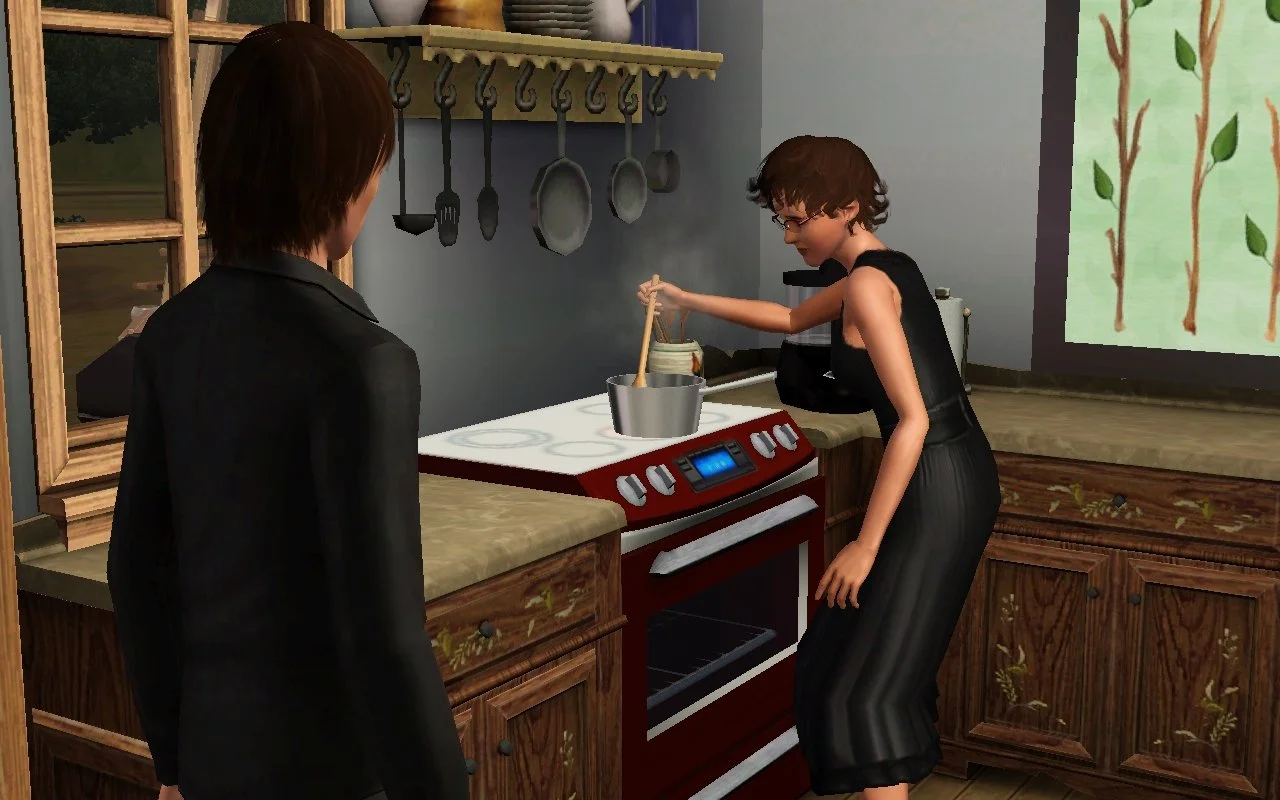 Aria, stirring spaghetti on the stove, turns slightly towards Young Adult Sim Chase standing a few feet away. Her expression looks concerned or sad. Both are dressed in black formalwear.