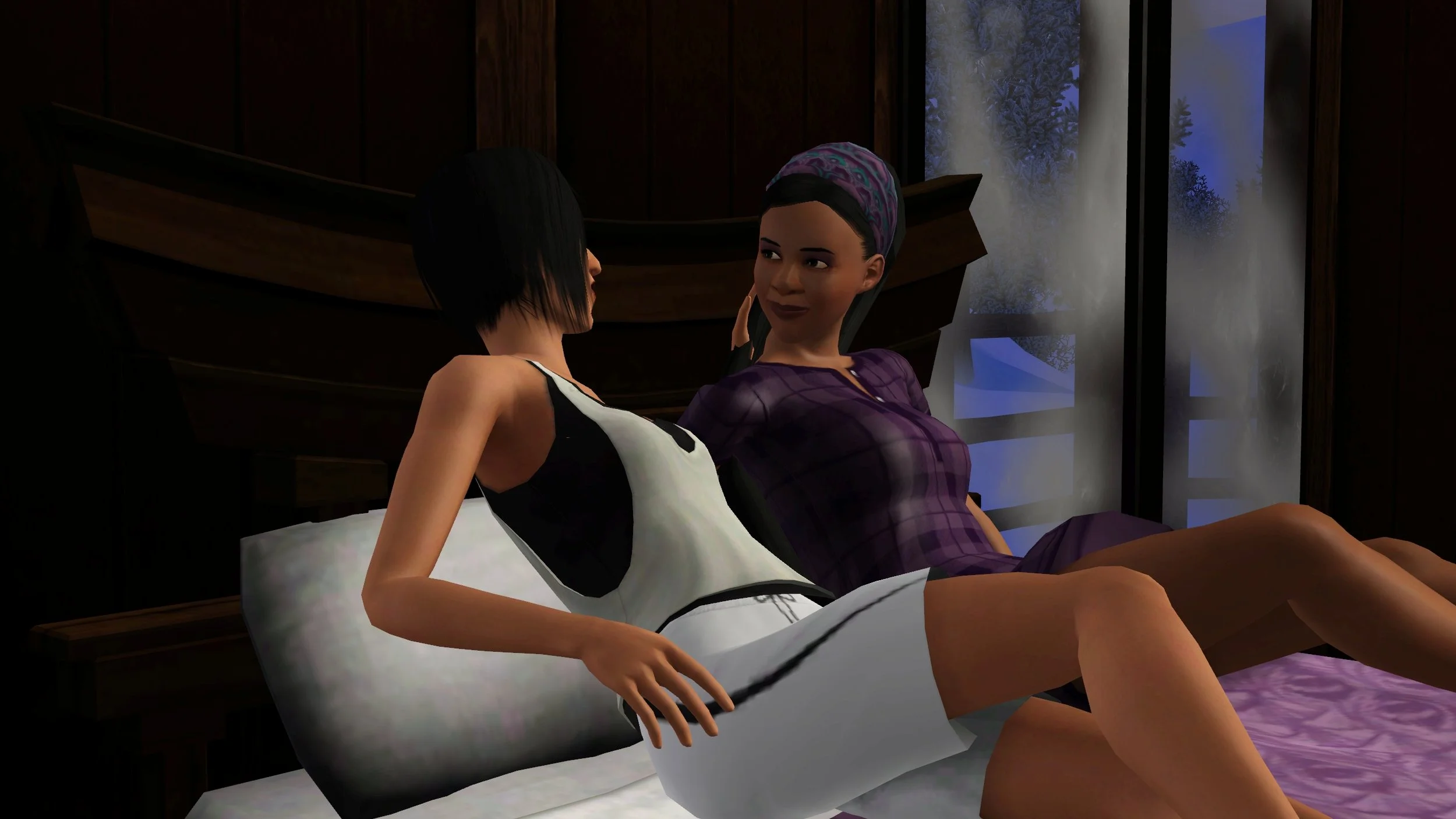 Viewed from Colette’s side, she and Emery lean against pillows on her bed, next to frosted windows. Colette has one hand in Emery’s hair, and Emery is looking at her with a neutral expression or small smile.