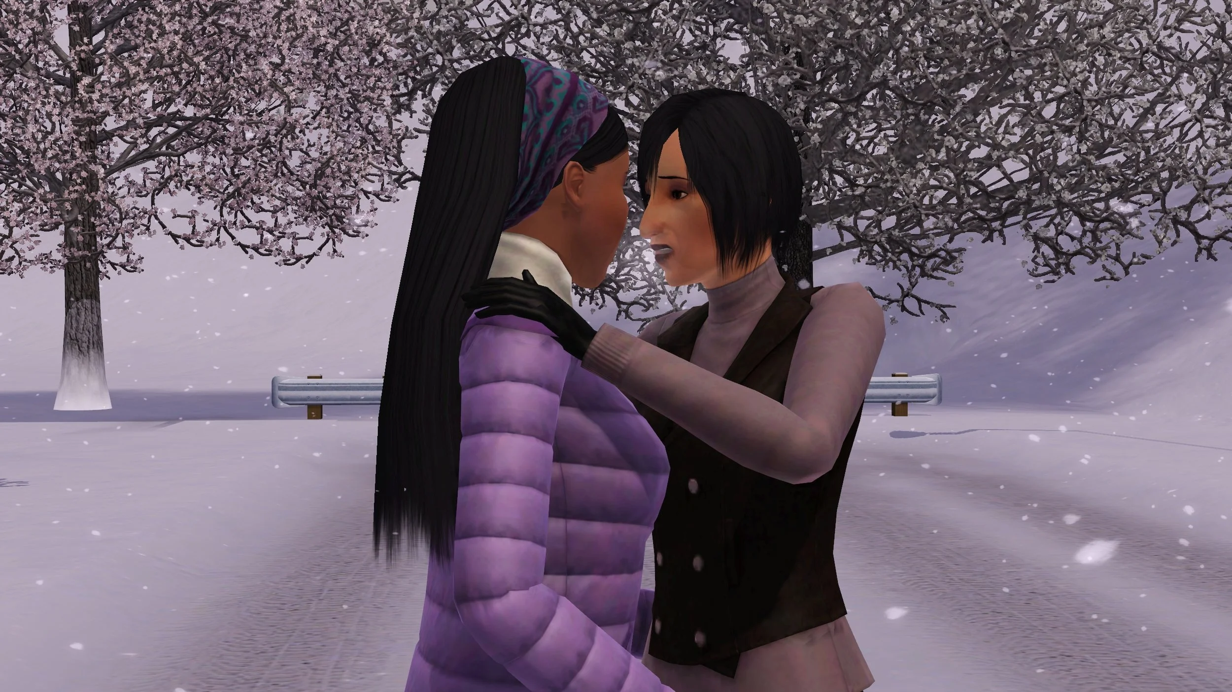 Colette looks directly into Em’s eyes as though telling her something important, a hand on the shoulder of her puffy winter coat, her breath forming a cloud in the cold air. Snow falls around them standing closely on a snow-covered dead-end road.