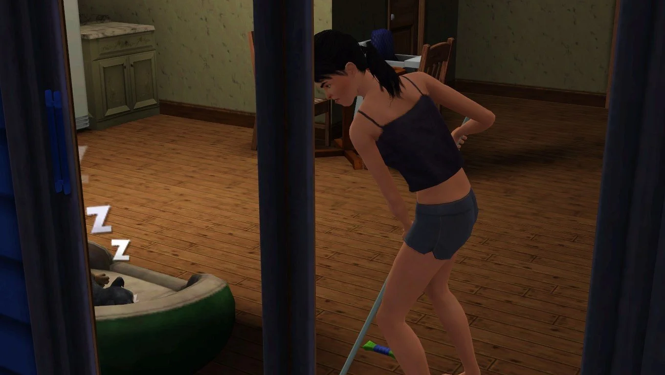 Dorothy mops the floor at the sliding door in the kitchen at the back of the Button Ranch home, next to a large pet bed where dog Petunia is sleeping. A high chair is next to the dining table. Dorothy wears a tank top and shorts.