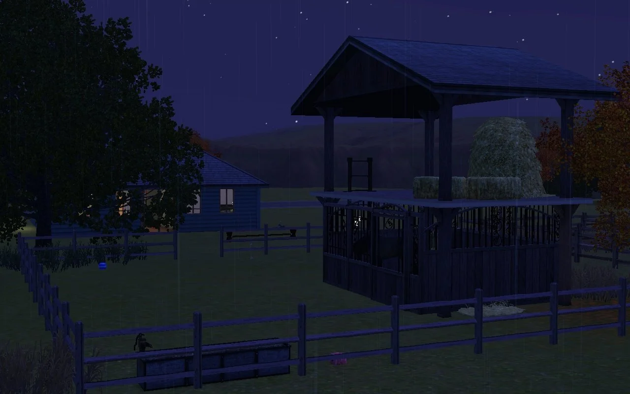 Subtle streaks of rain fall on a night scene of a stable with a hayloft in a paddock behind a small one-storey ranch house. Appaloosa Plains’ trees, hills and night sky fill the background.