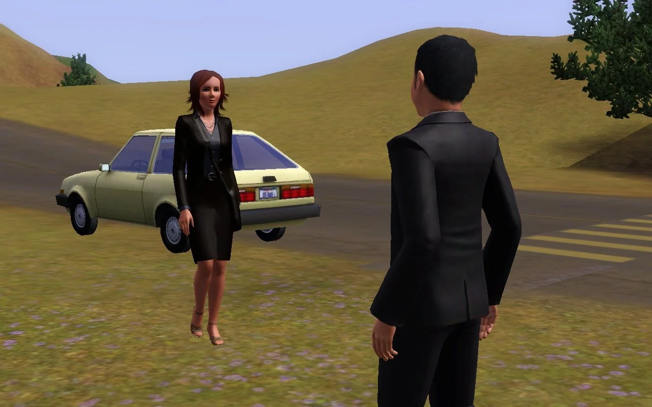 Appaloosa Plains Townie Sim Alani Shepherd walks towards Mason Tevellyn, both dressed in black blazers and other dark formalwear. Behind Alani is a small, dated hatchback car parked at the edge of the road.