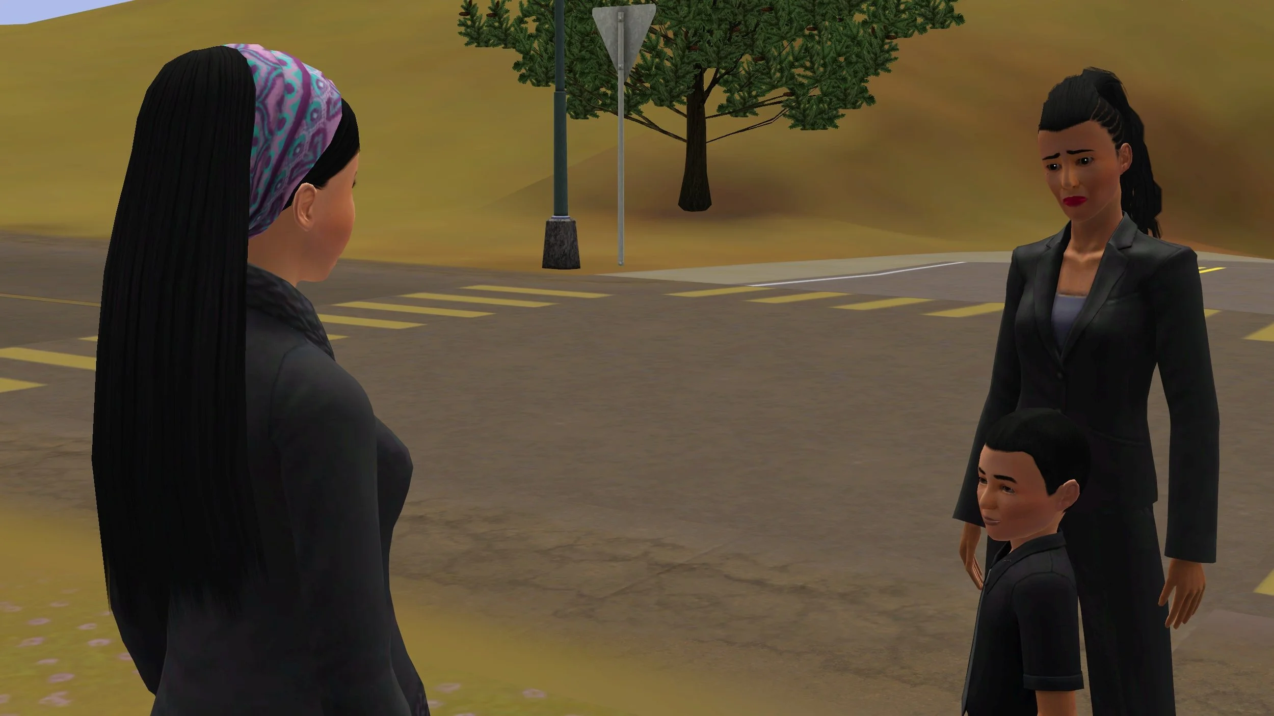 Rukiya Shabani stands roadside with a frown and furrowed eyebrows, wearing a black blazer and dress pants. Her son Kobe stands in front of her, wearing a black collared shirt. Both are facing Emery Tevellyn, who awaited their arrival.