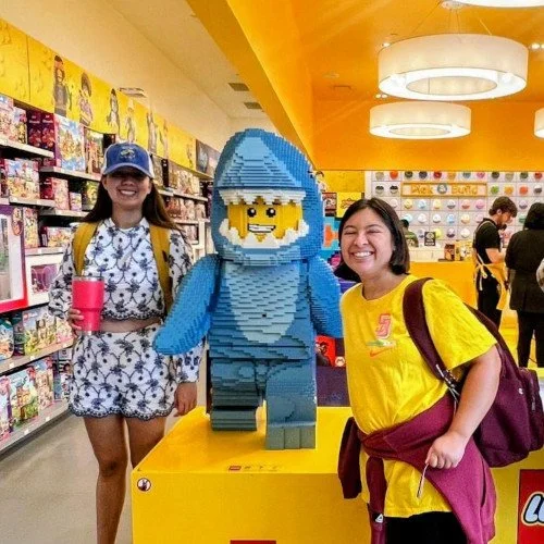 Three young men wearing sunglasses in a store with colorful shelves and toys.