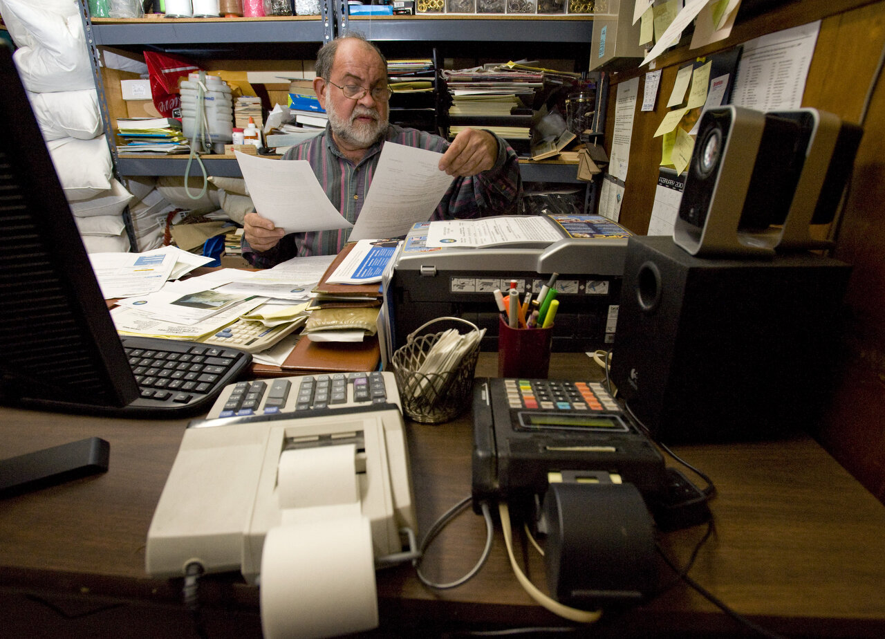 ANAHEIM, CA – Anaheim business owner Sergio Mairena reviews bills for glass repair and paint at his office on E. Lincoln Ave. on February 12, 2010. The neighborhood had been plagued by graffiti for decades, but, recently he said, etched graffiti on t