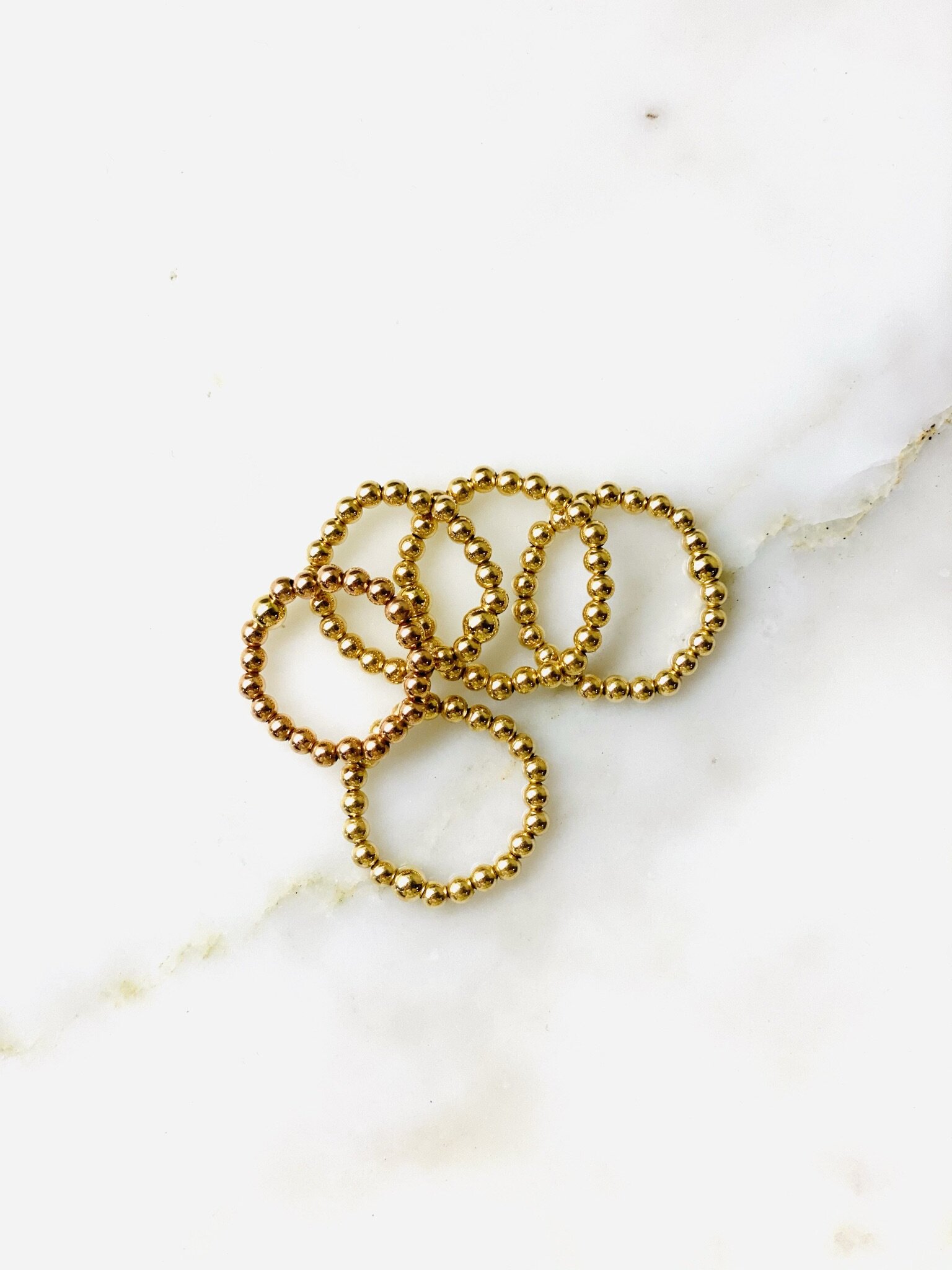 Image of multiple 3mm gold beaded rings.