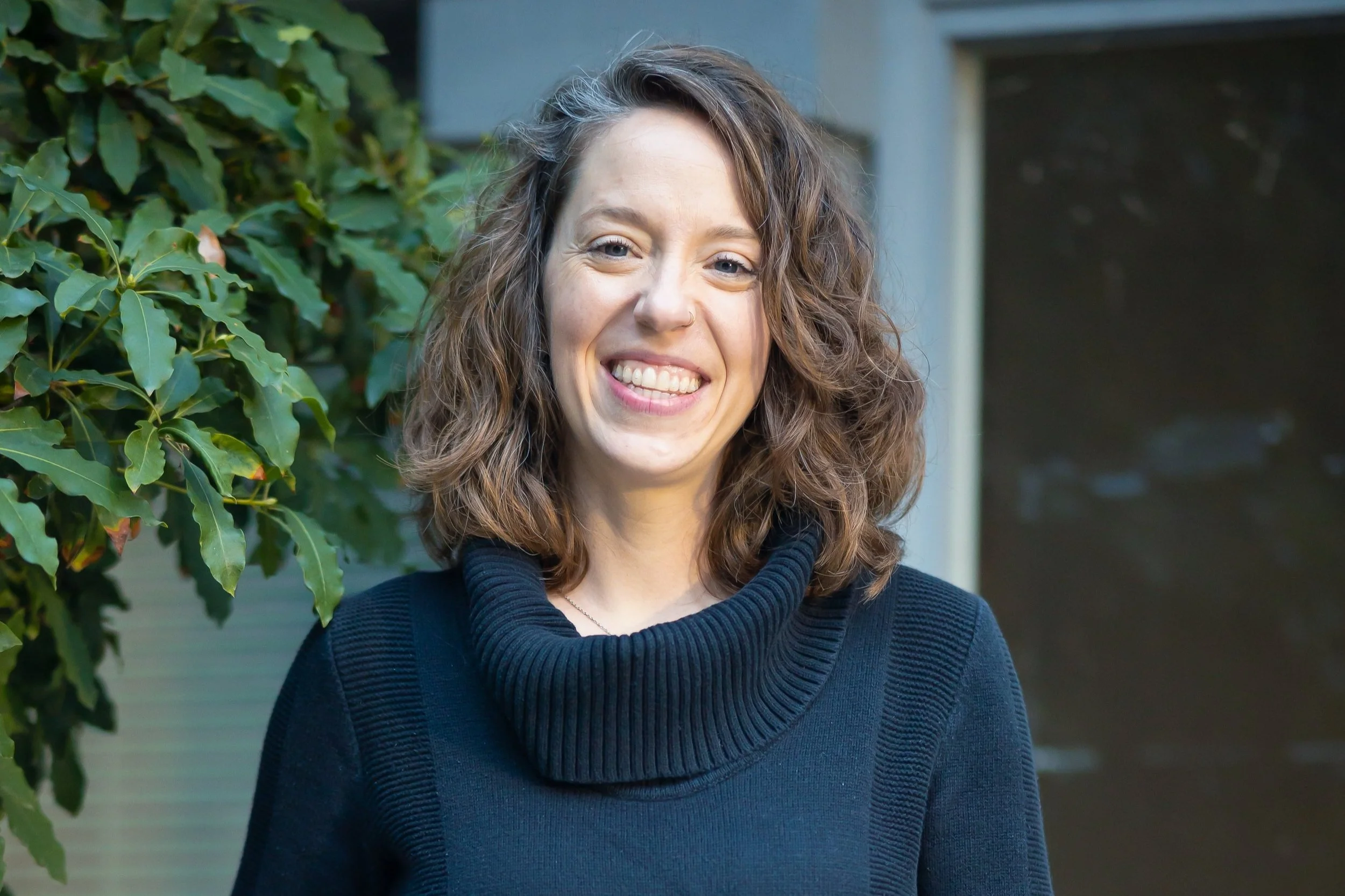 Becca is a therapist coach at zynnyme, a white woman with brown hair wearing a black sweater