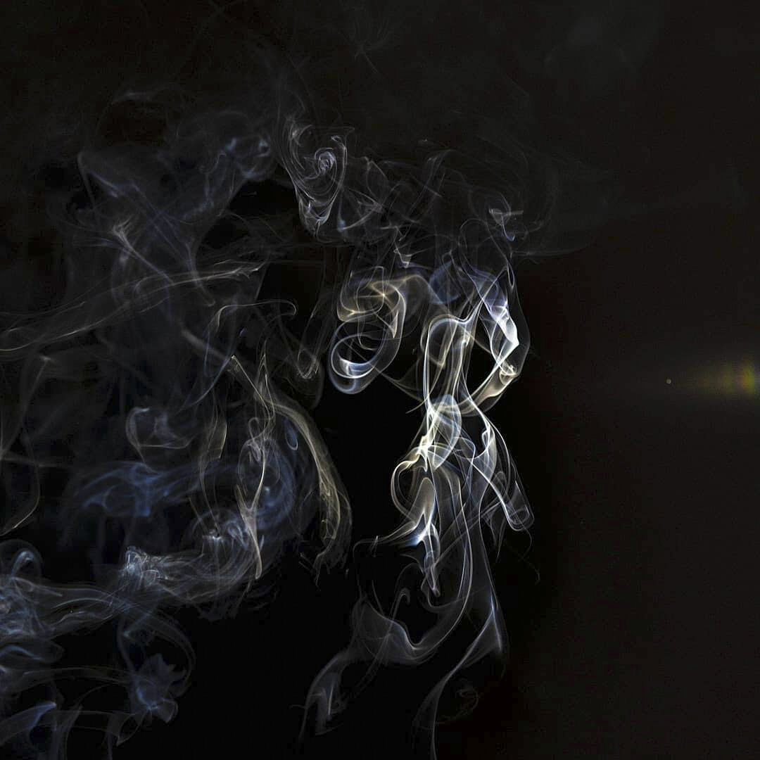 Swirling white and blue smoke against a black background.