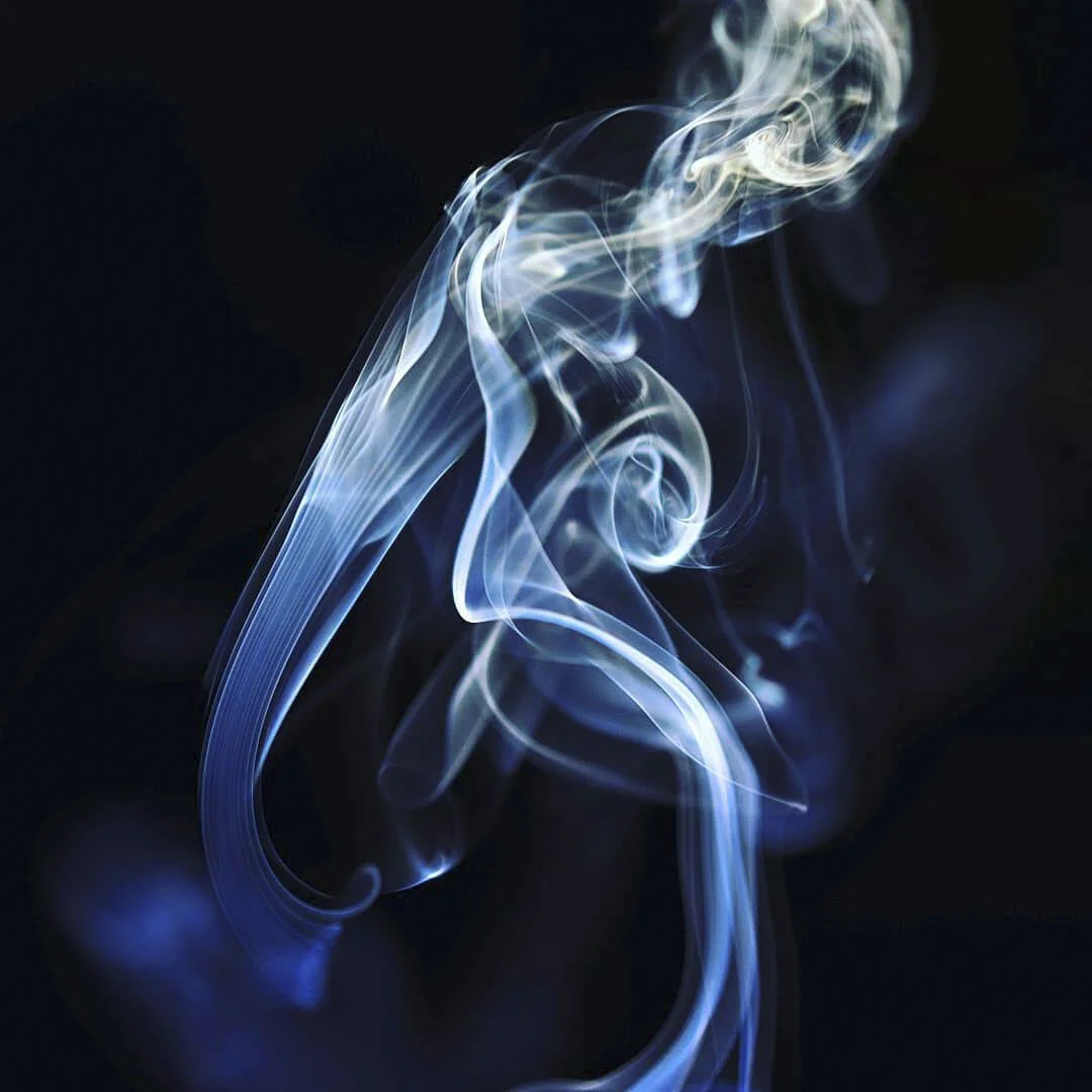 Blue and white wisps of smoke swirling against a black background.