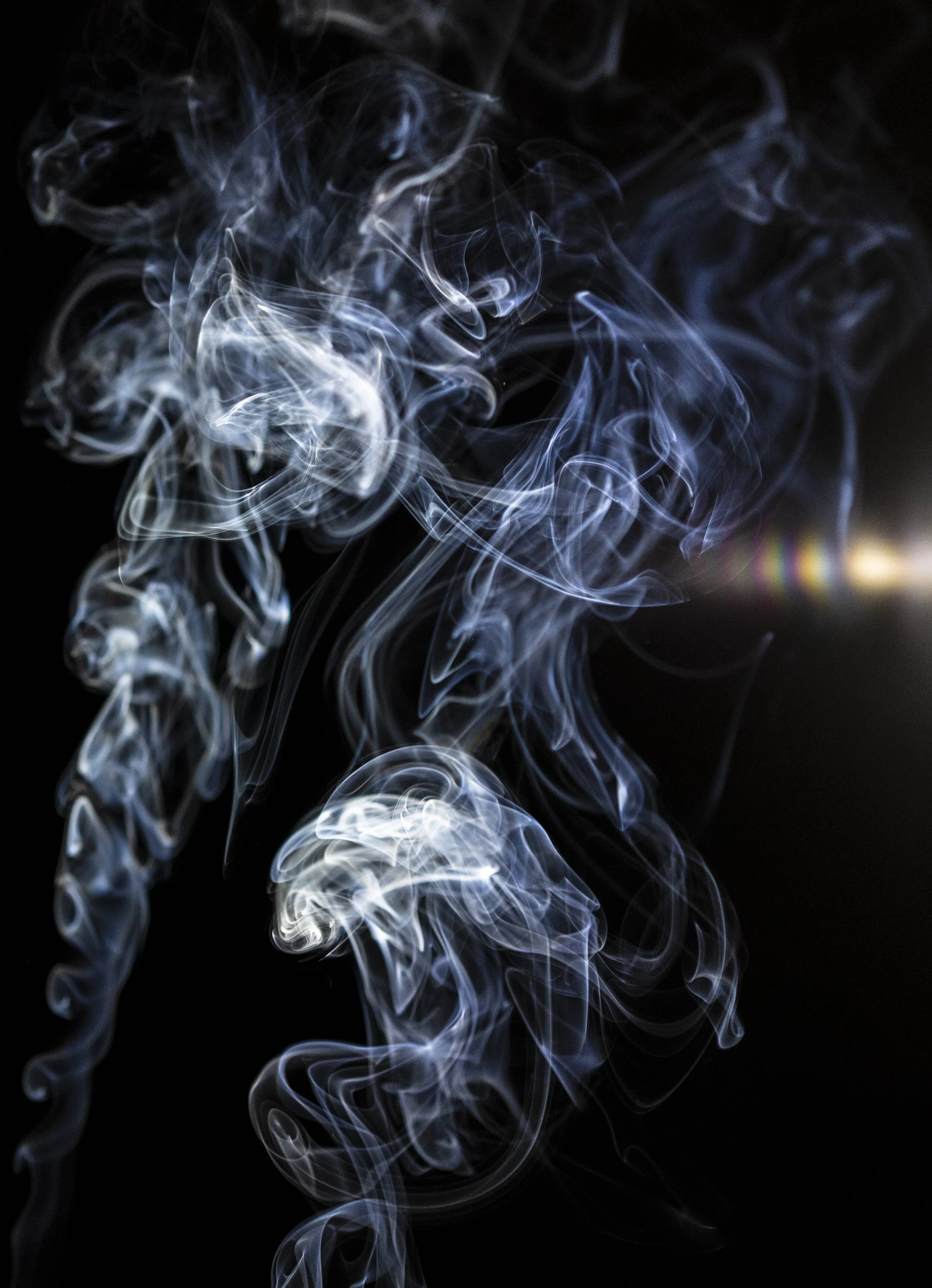 Swirling white smoke trails against a black background.