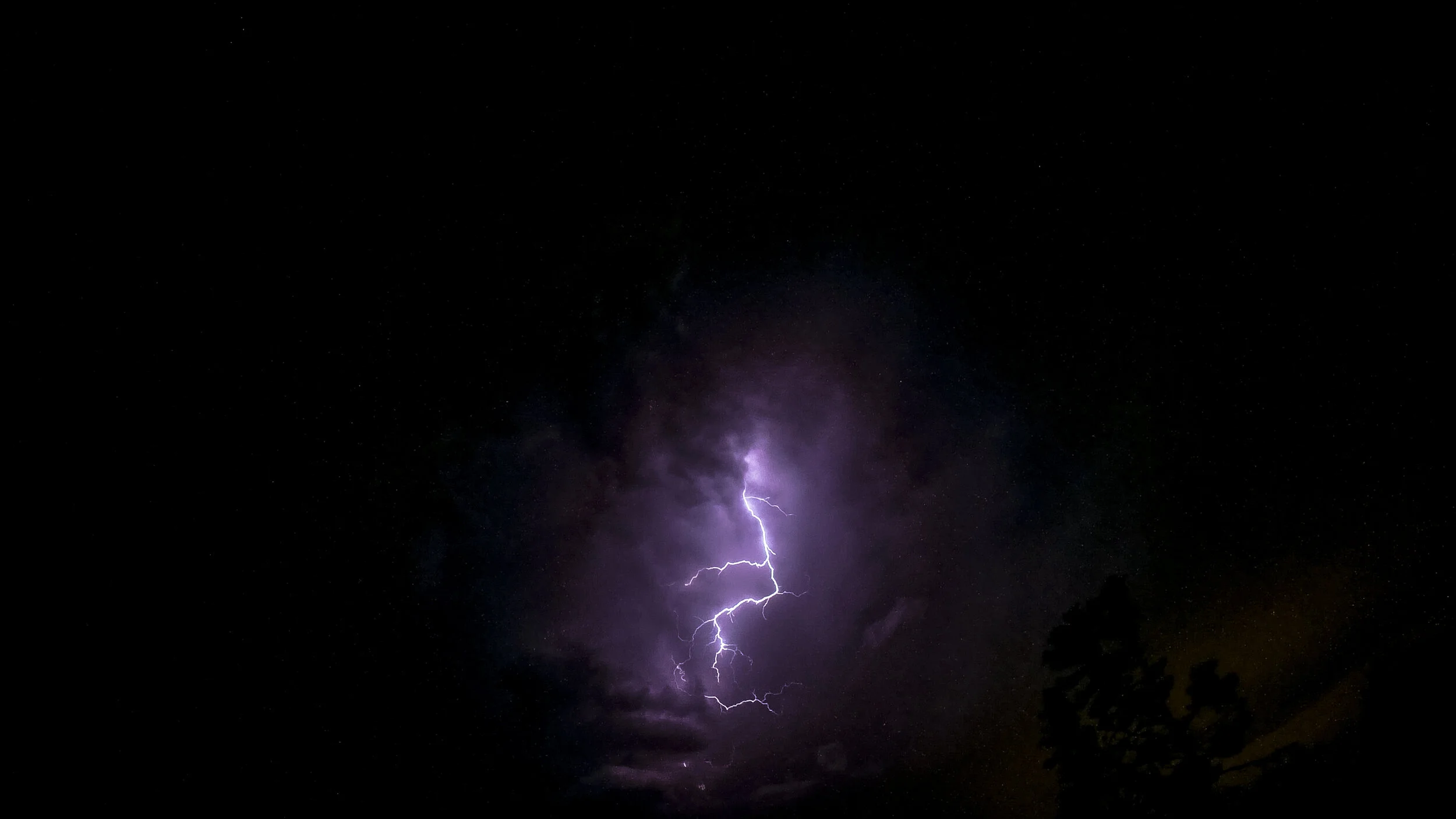 A lightning bolt striking through a dark night sky.