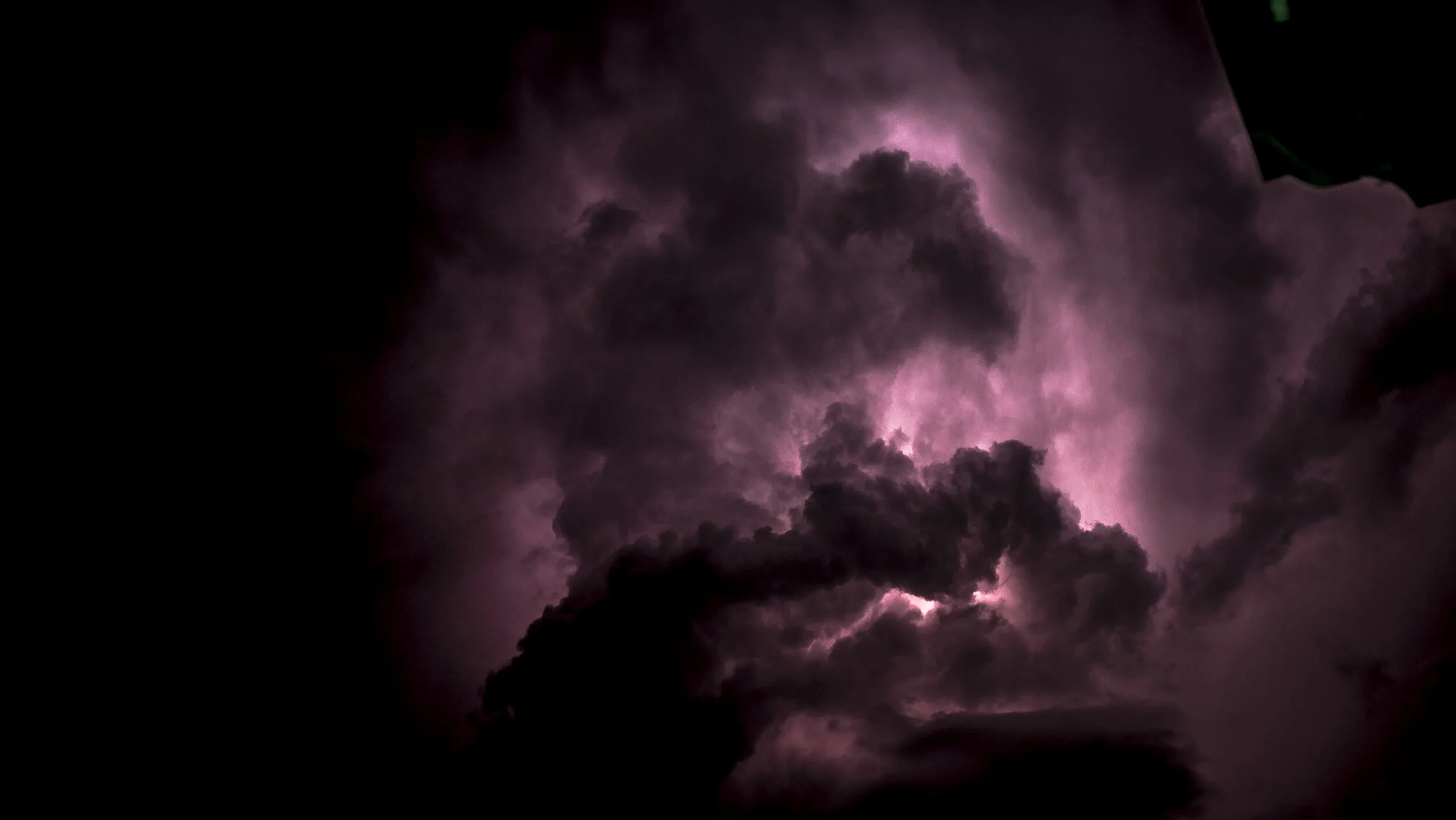 Dark storm clouds with pink lightning visible in the sky.