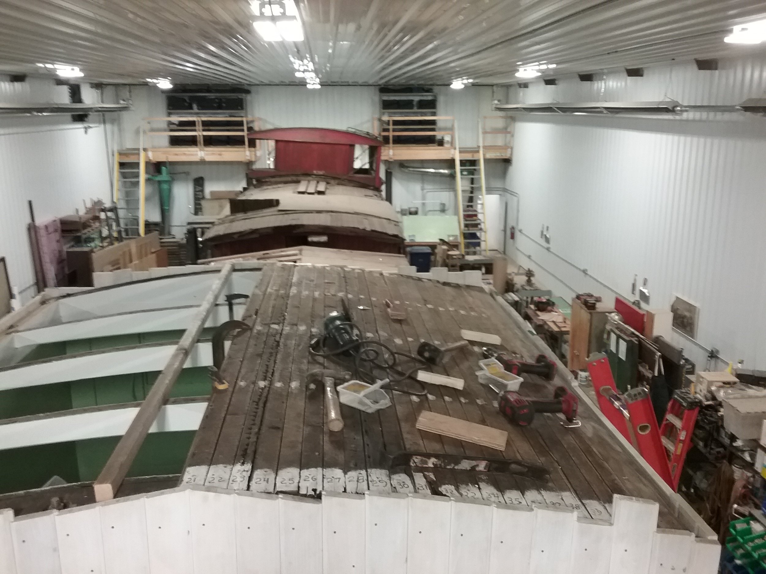  Roof reassembly continues, with primed ceiling joists and roof panels being installed.  