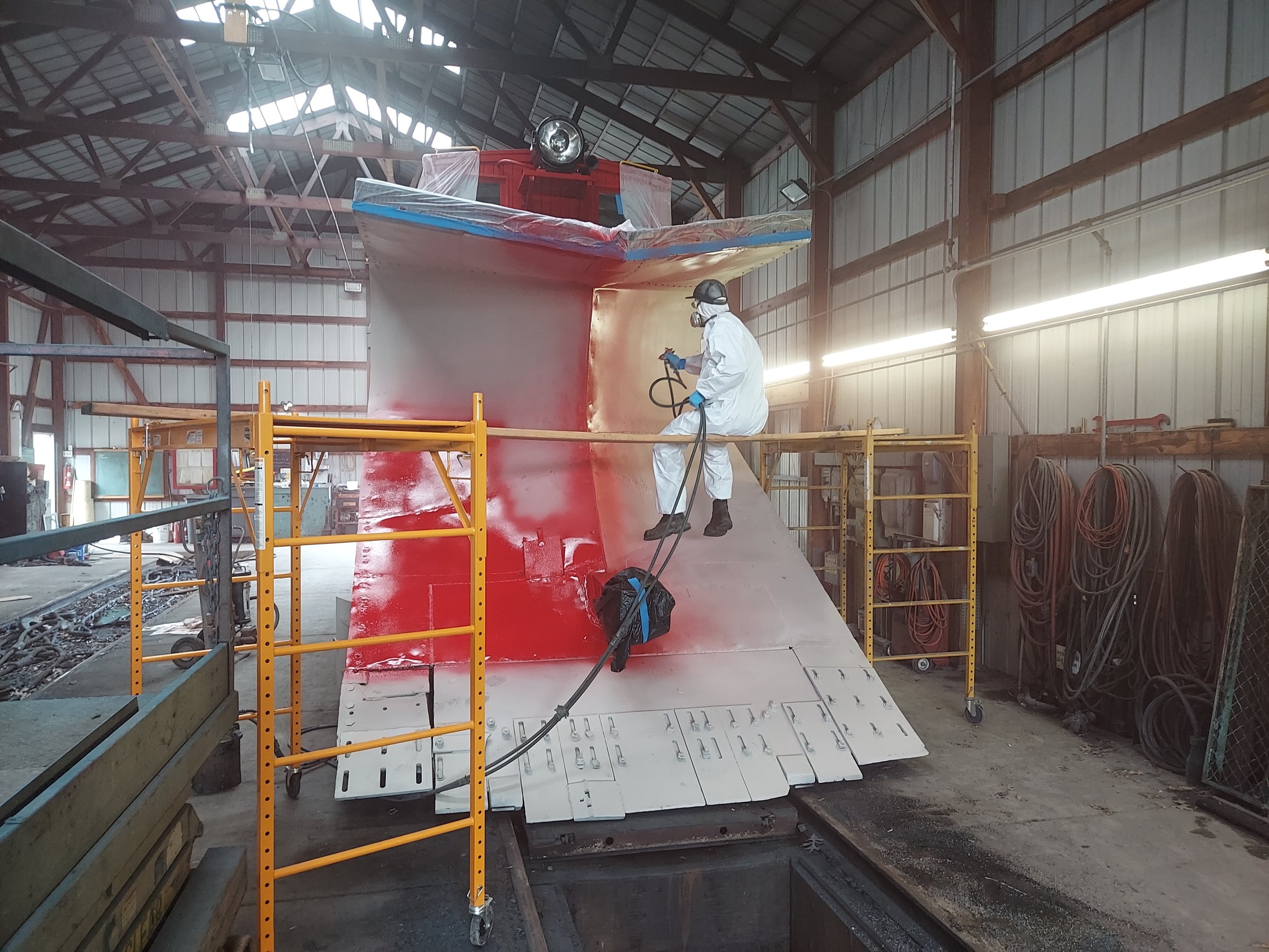  Repainting the snowplow started with spraying red paint on the plow.  