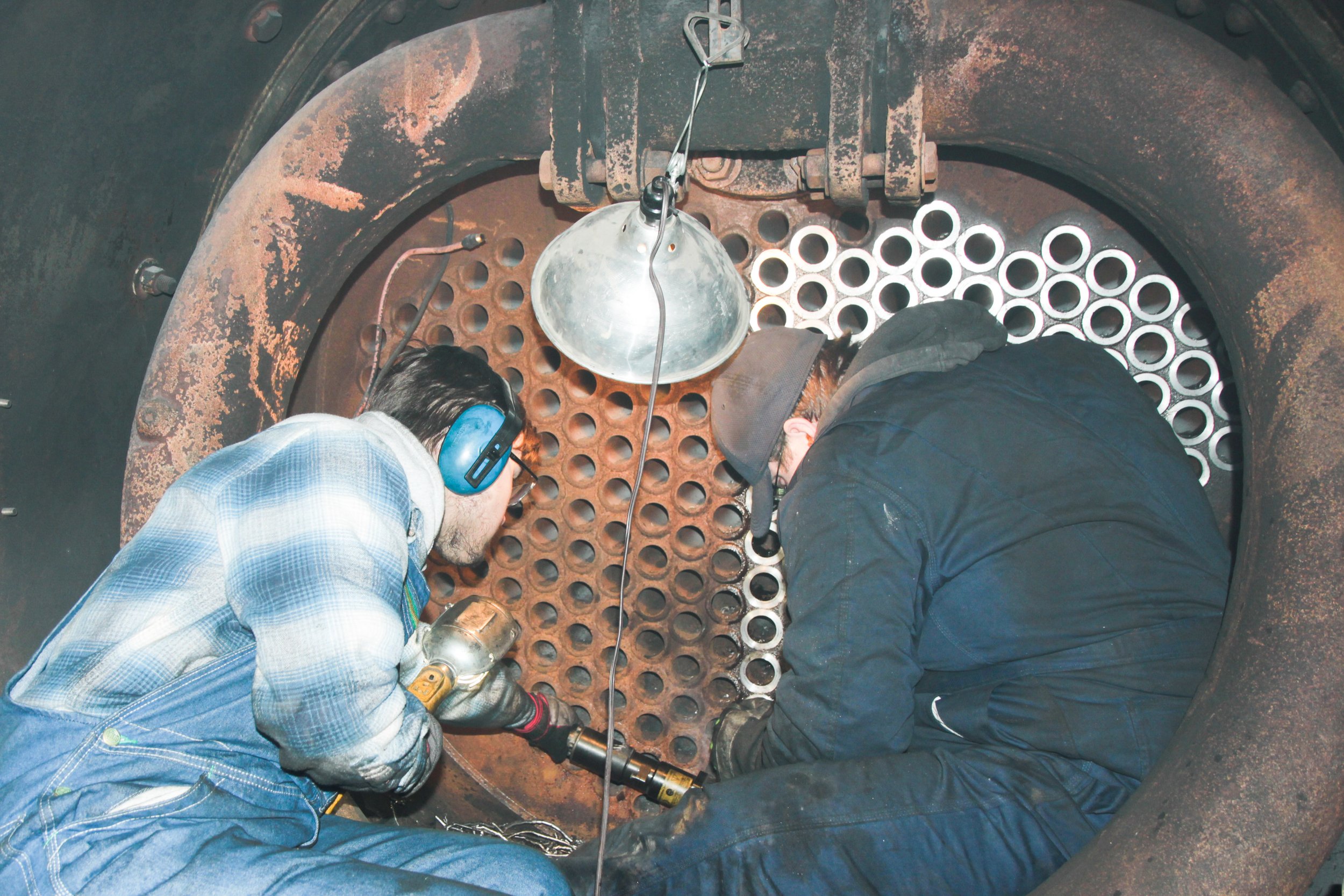 The tubes are held in place in the boiler by tube sheets at the front and rear of the boiler. Here, volunteers are trimming welds off the front tube  sheet.  