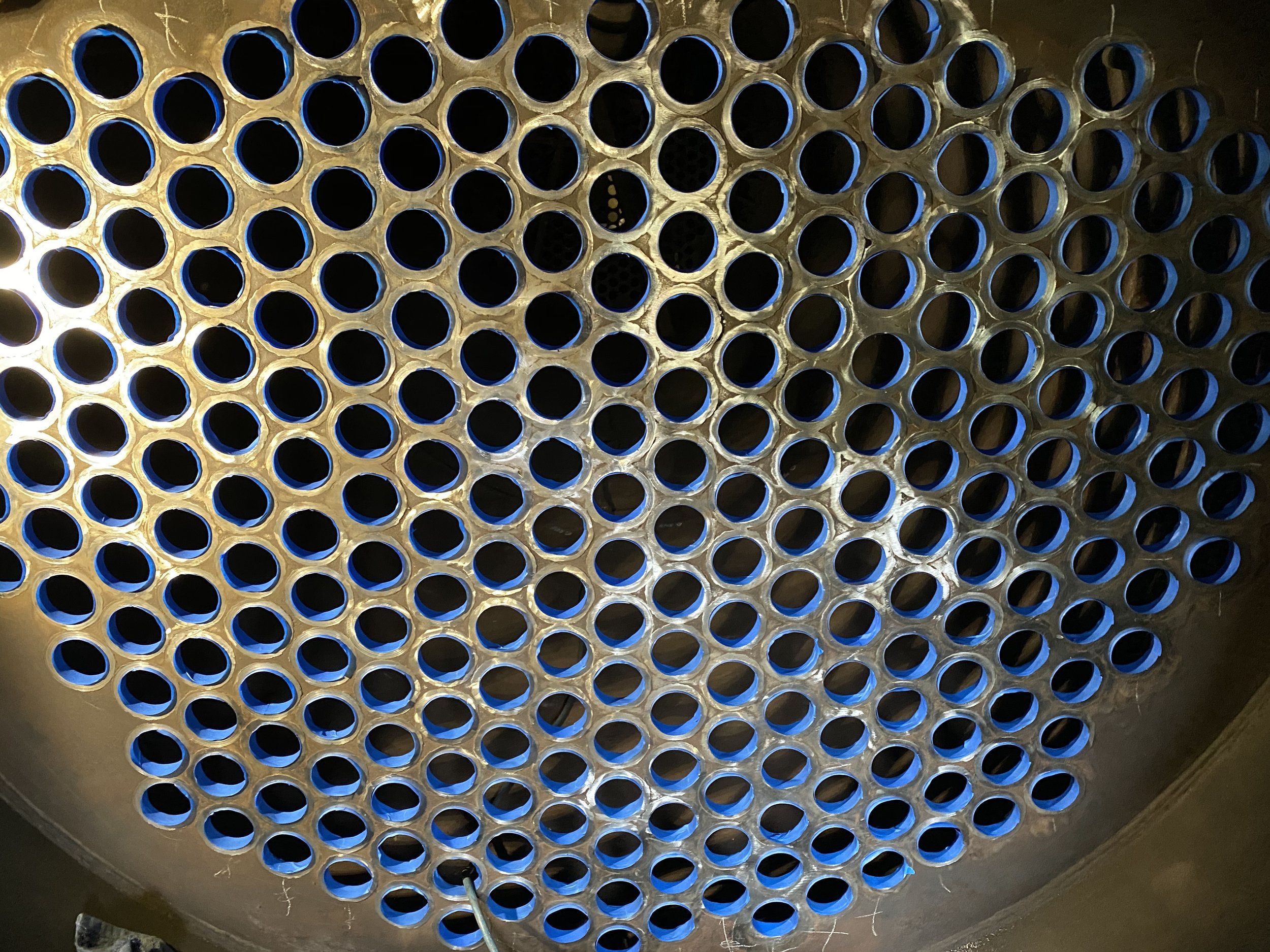  In advance of sand blasting and coating the boiler, volunteers meticulously applied tape to both tube sheets. This ensures the mating surface where the tube enters the tube sheet remains clean.  