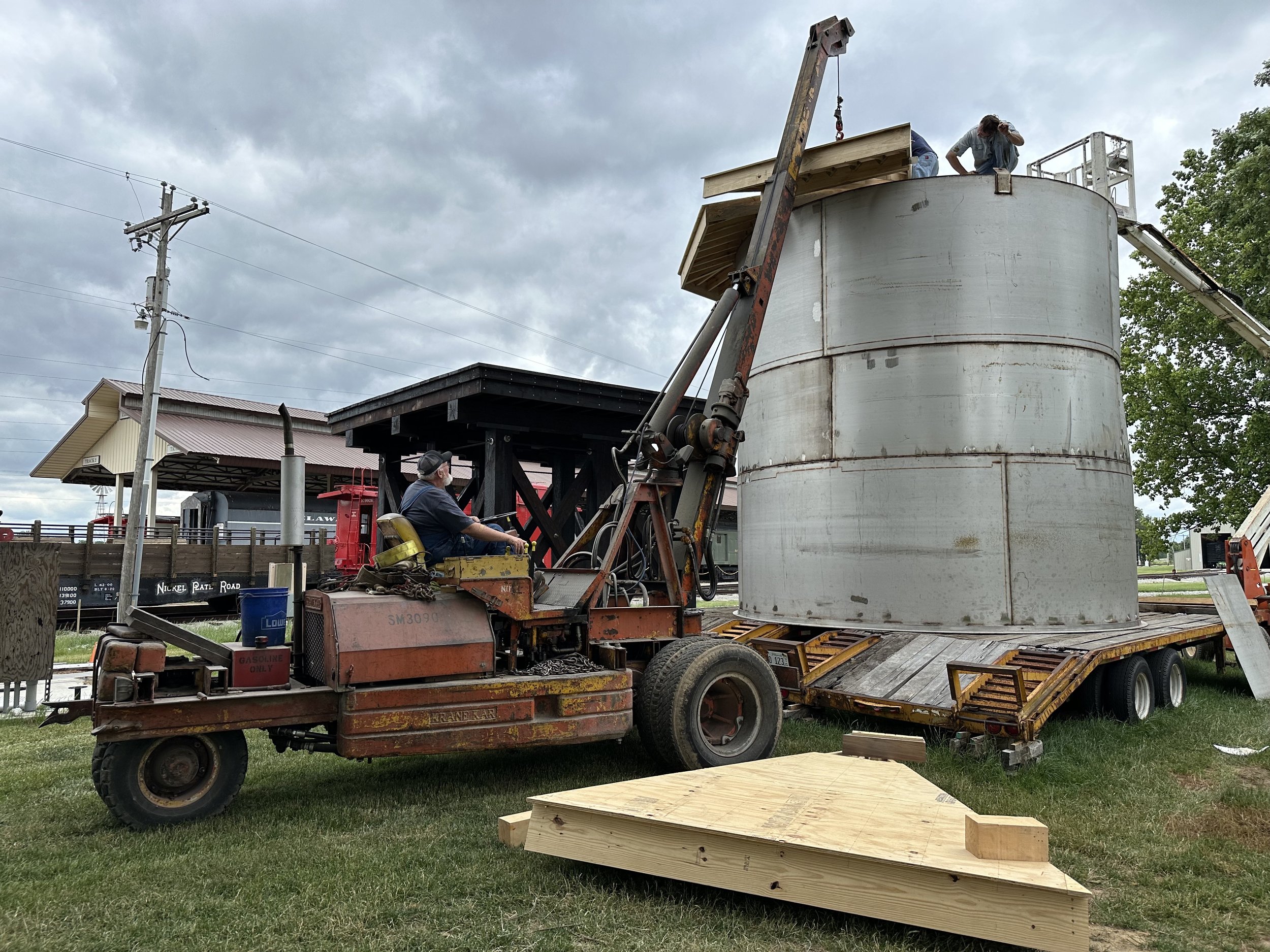 Once welding the tank was complete, roof installation began. The roof is shown being installed in sections by volunteers. Carefully measurements and adjustments were required to align the individual sections correctly.