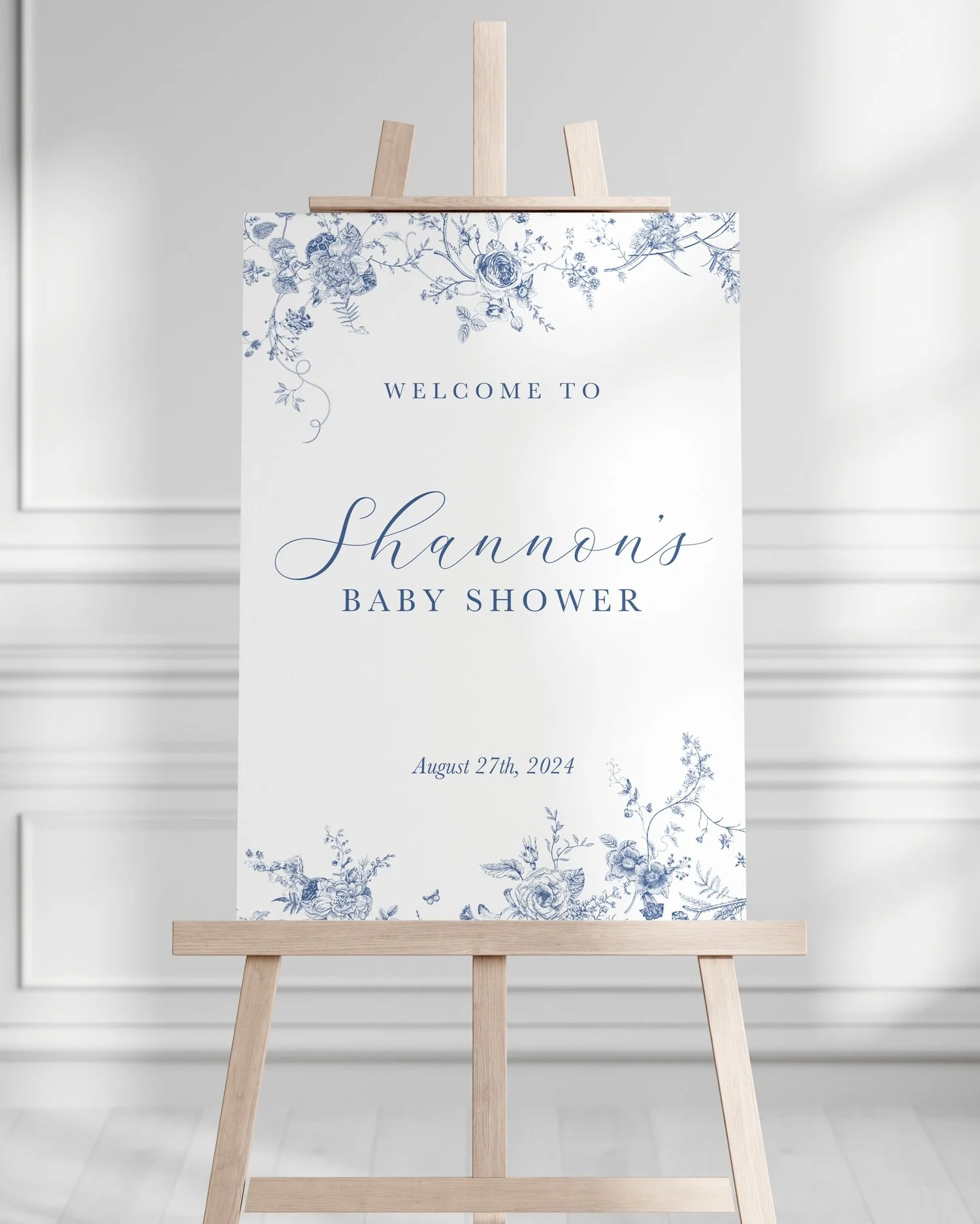Welcome sign for Shannon's baby shower with blue floral accents and the date August 27th, 2024, on an easel.