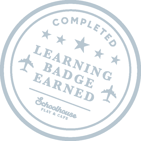 A silver badge from Schoolhouse Play & Cafe indicating the person has completed learning, earned a badge, and received a star.