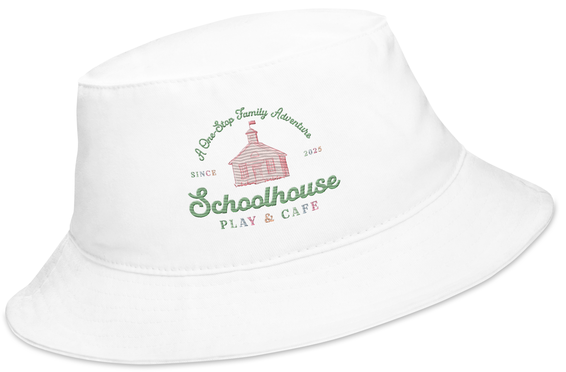 White bucket hat with a colorful embroidered logo featuring a schoolhouse, the text "A One Stop Family Adventure," "Since 2025," "Schoolhouse," and "Play & Cafe."