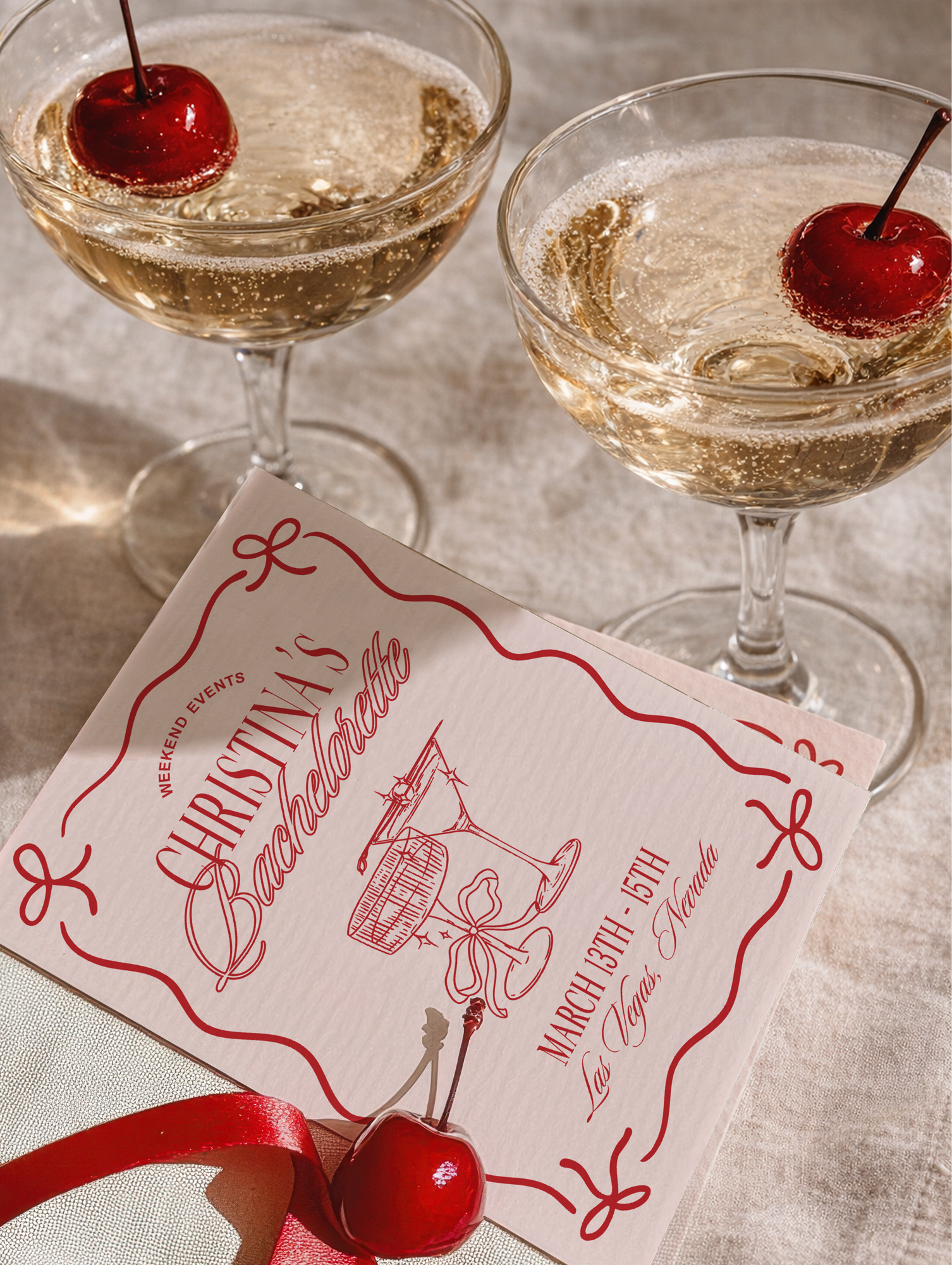 Two champagne glasses with cherries and a Christmas-themed event flyer.