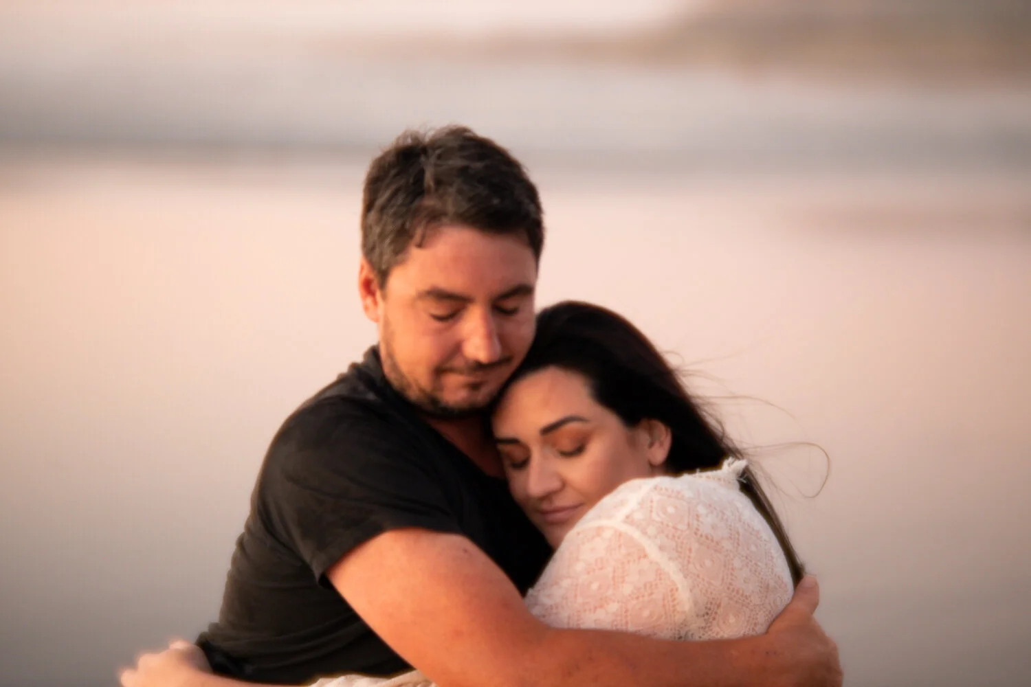 A couple embrace with with shadows on their faces at an auckland maternity session-5.jpg