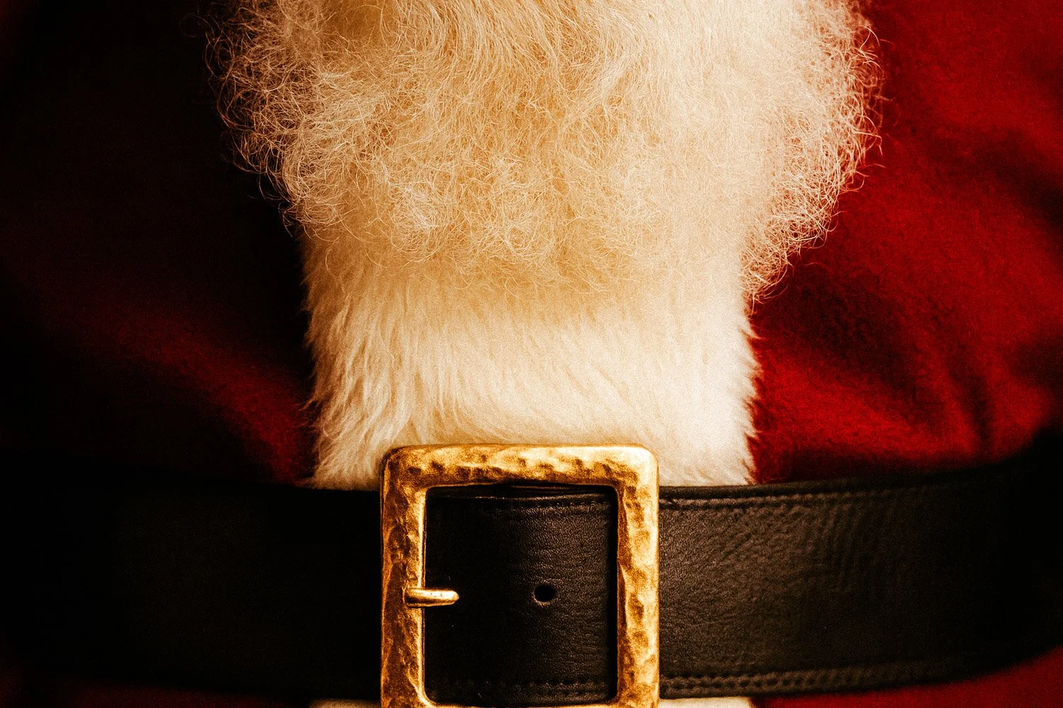 Close-up of a Santa Claus costume belt with a gold buckle and white fluffy trim.