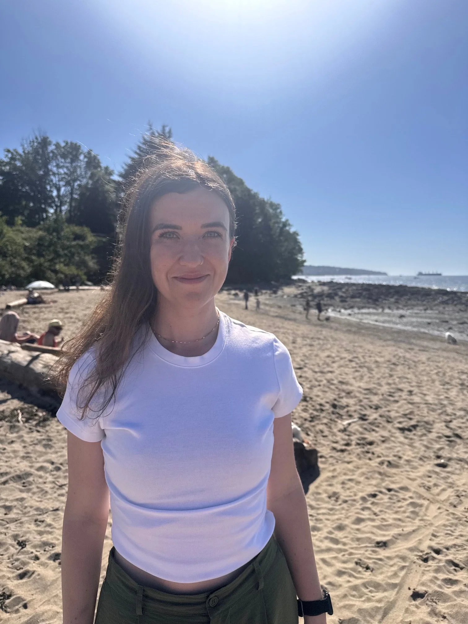Steph, a Raintown trainer and dog walker, smiles at the camera in at Kitsilano Dog Beach in Vancuver..