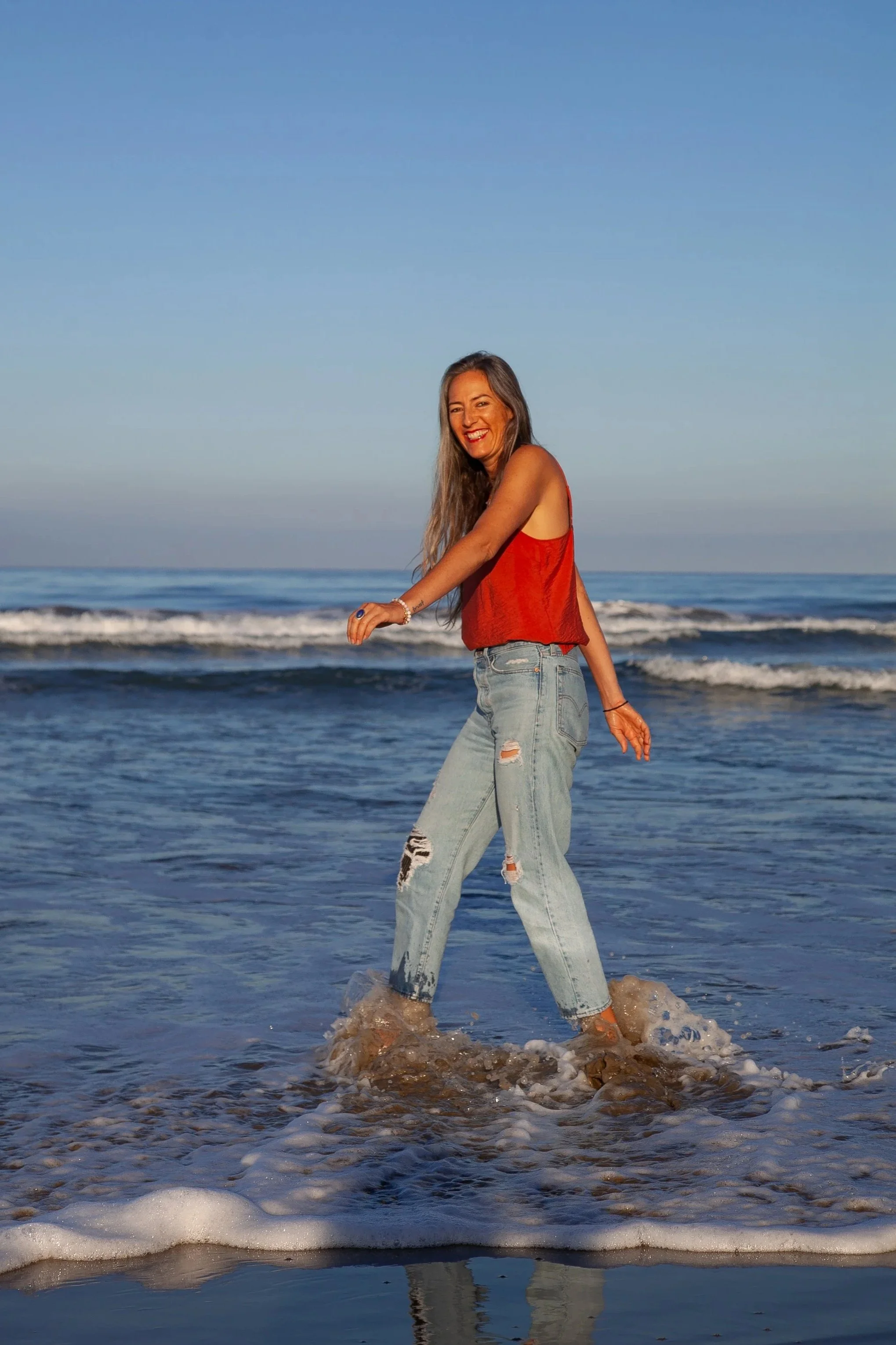 Woman smiling, walking in the ocean