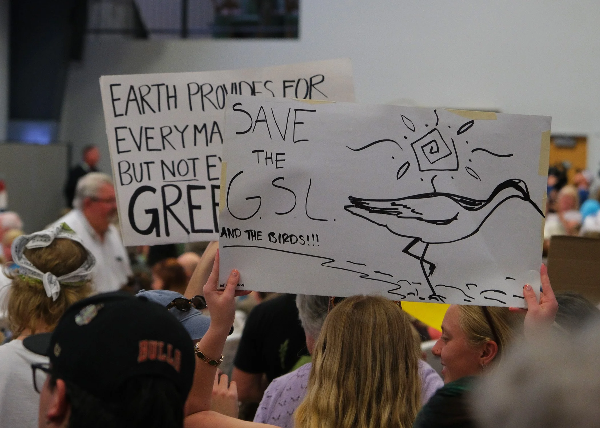 Protesters clutch signs calling to save the Great Salt Lake, a primary concern among attendees at the Box Elder County meeting on May 4. 