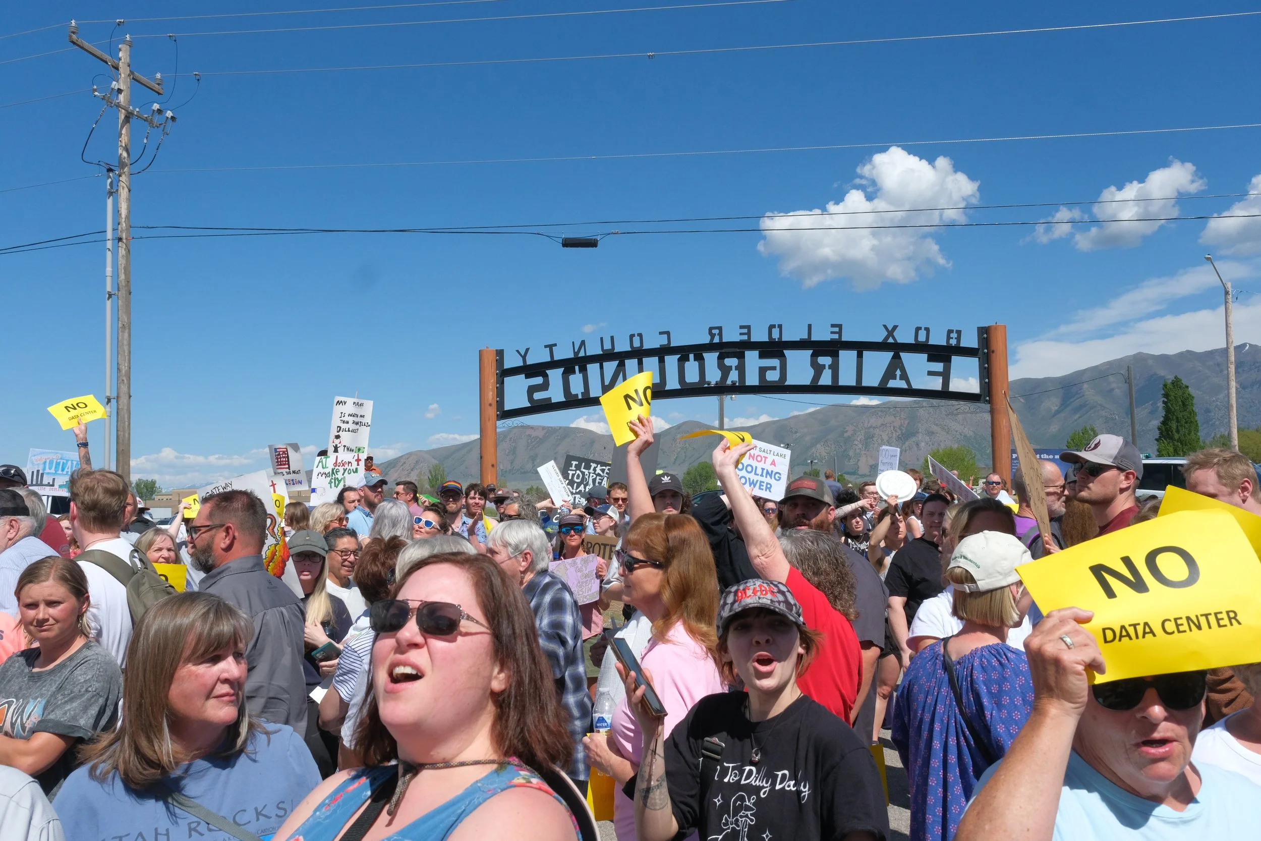 A crowd gathers outside the Box Elder County Fairgrounds as speakers address a rally before the meeting on May 4.