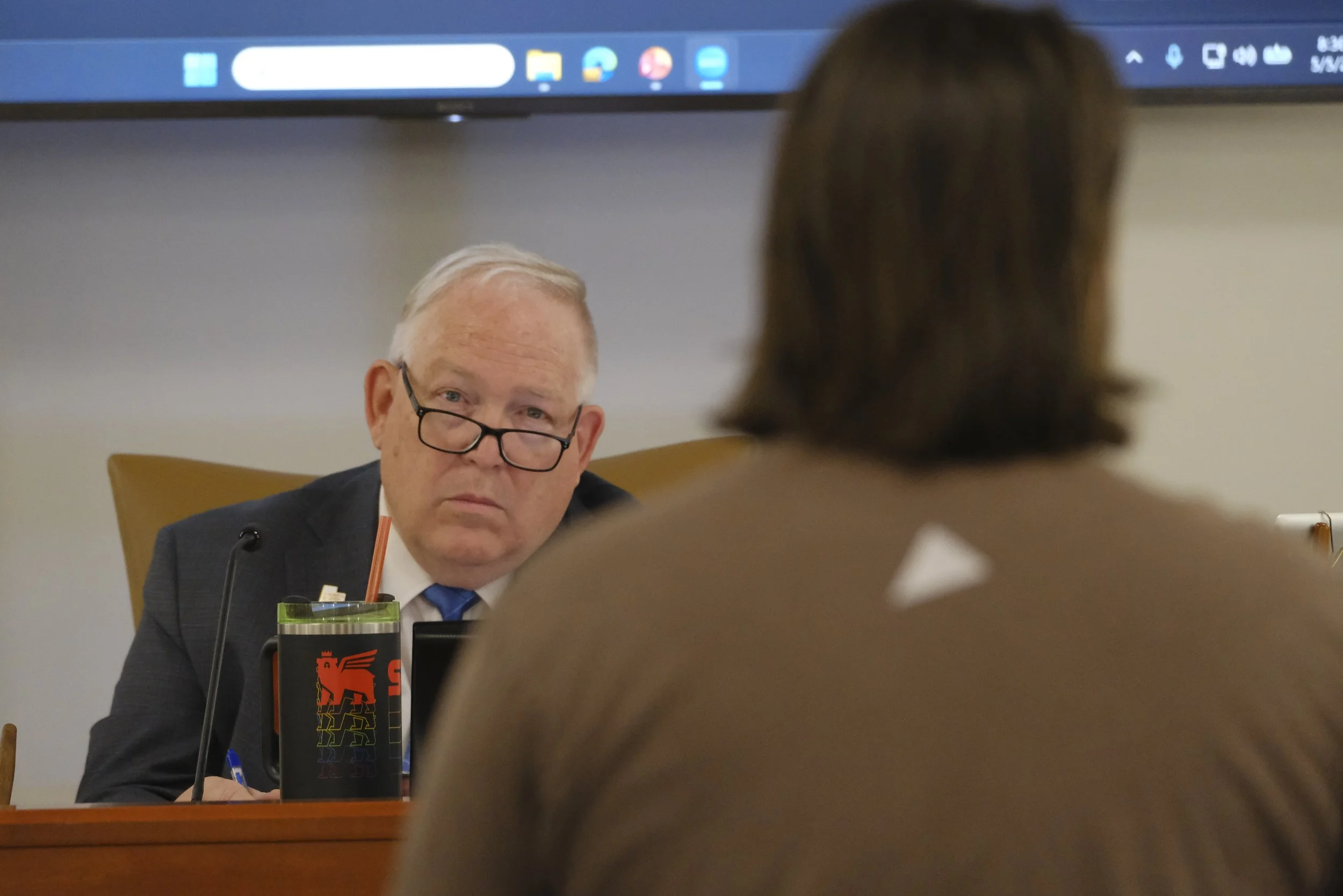 Chair Richard Hyer watches as Lucky Slice Pizza co-owner Nick VanArsdell urges council members to delay the vote on paid parking.
