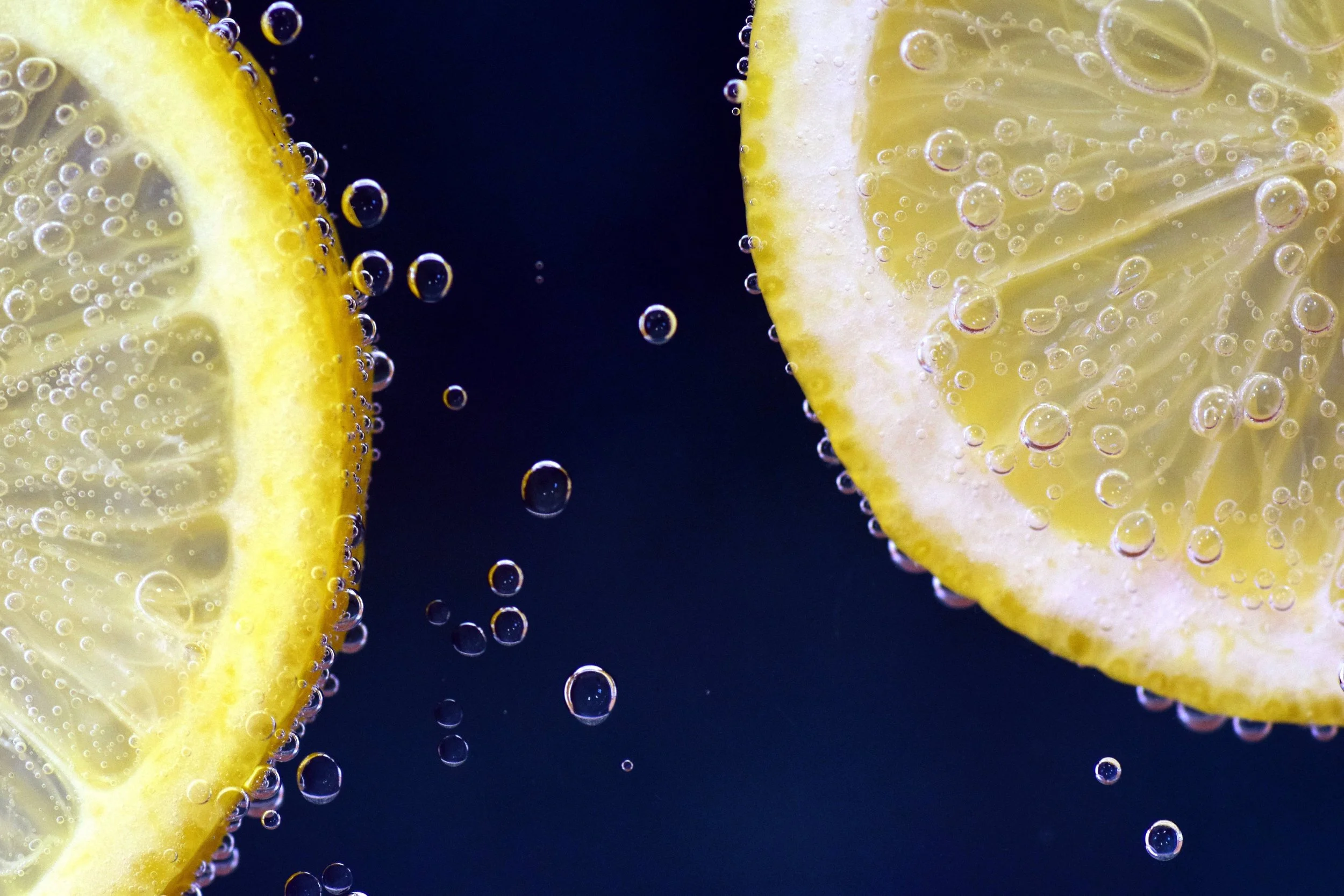 Two lemon slices on left and dipped in water.