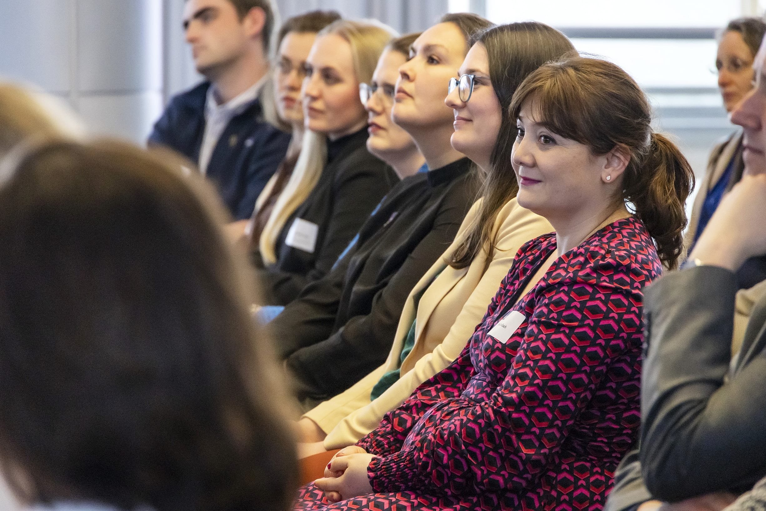 Menschen sitzen bei einer Konferenz und hören aufmerksam zu.