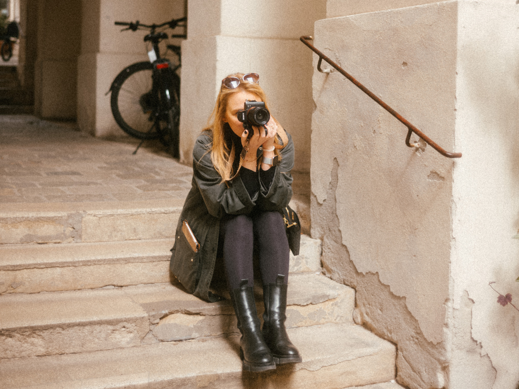 Eine Frau sitzt auf einer Treppe und macht ein Foto